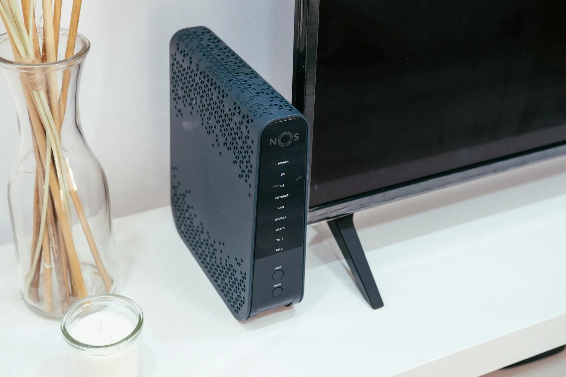 A sleek home technology setup featuring a router, glass decoration, and television.