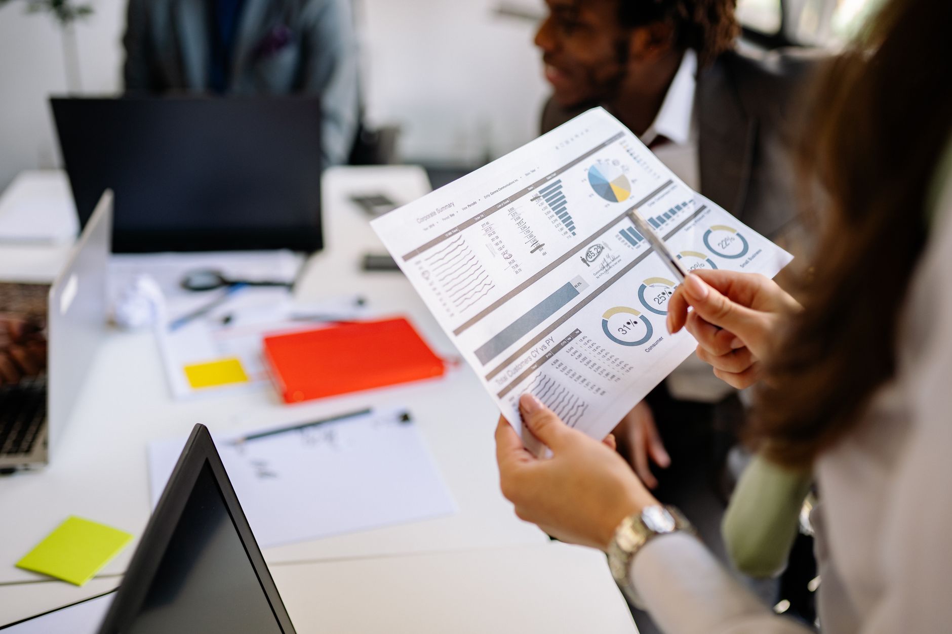 Colleagues reviewing printed performance charts together in a meeting