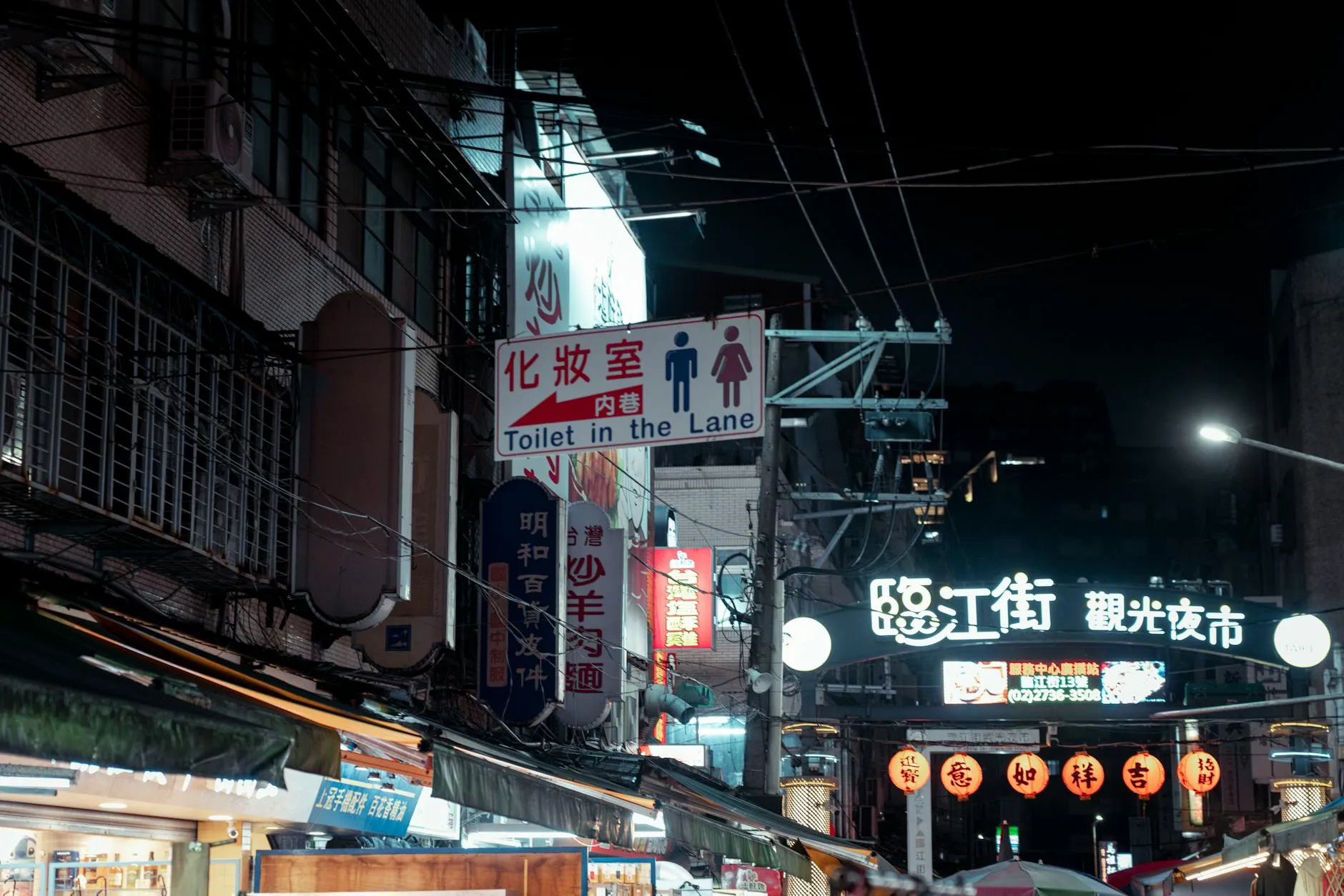 Explore the bustling night market in Taipei, Taiwan, with vibrant street signs and a lively atmosphere.