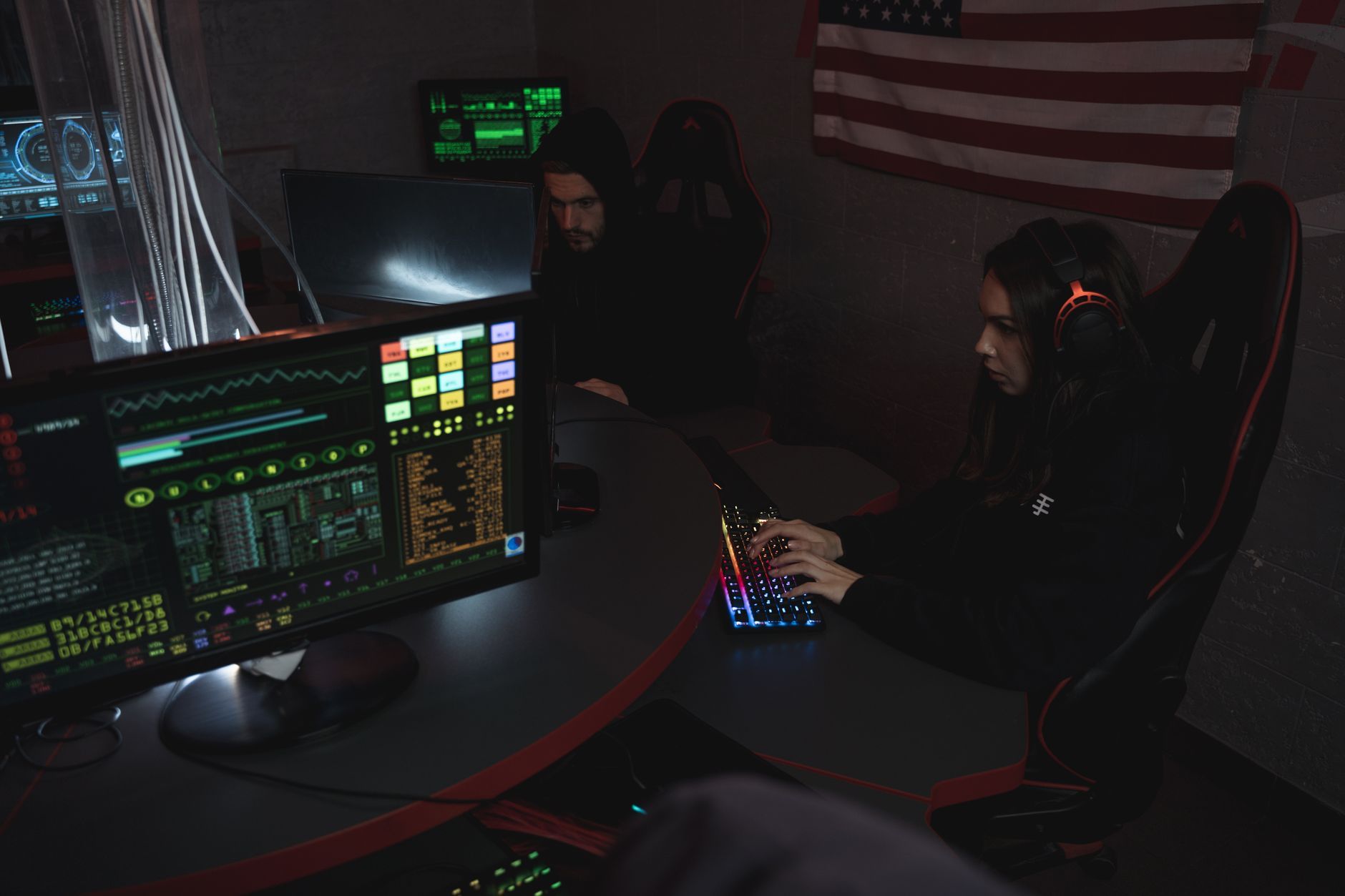 Two analysts working side by side at monitored workstations, representing the continuous detection capability that determines what a cybersecurity incident ultimately costs