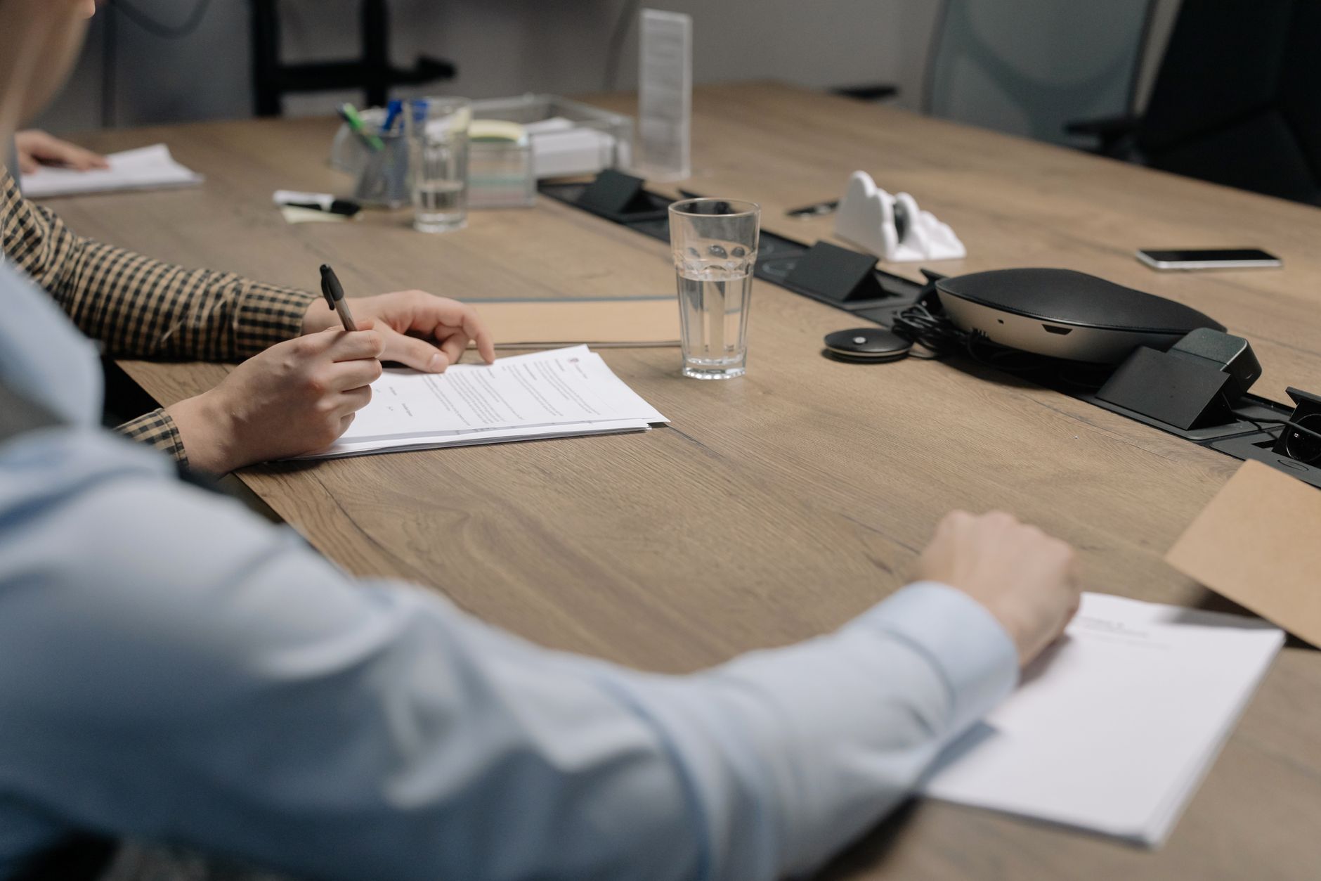Business documents spread across a conference table during a contract review