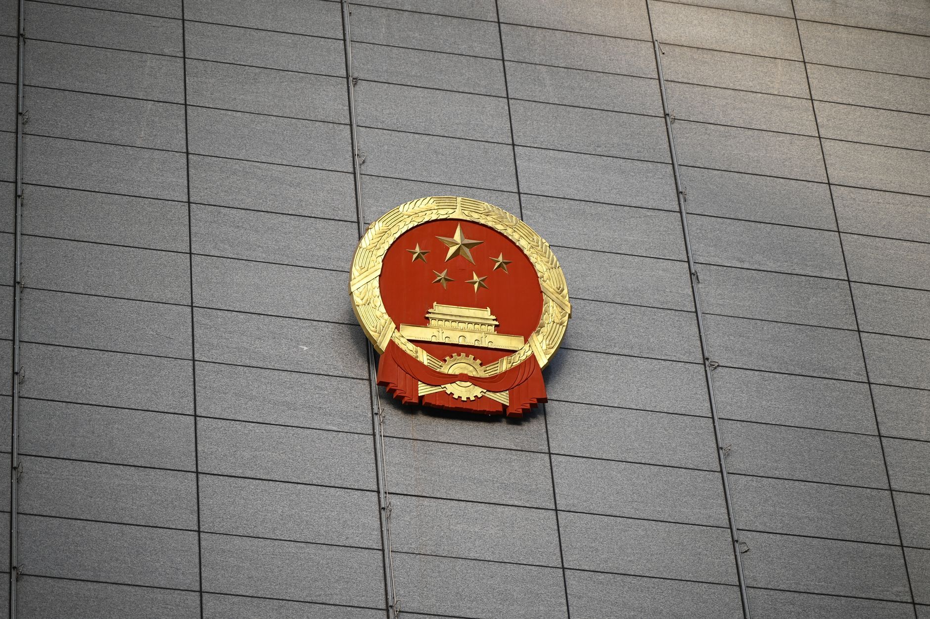 The Chinese national emblem on the facade of a government building