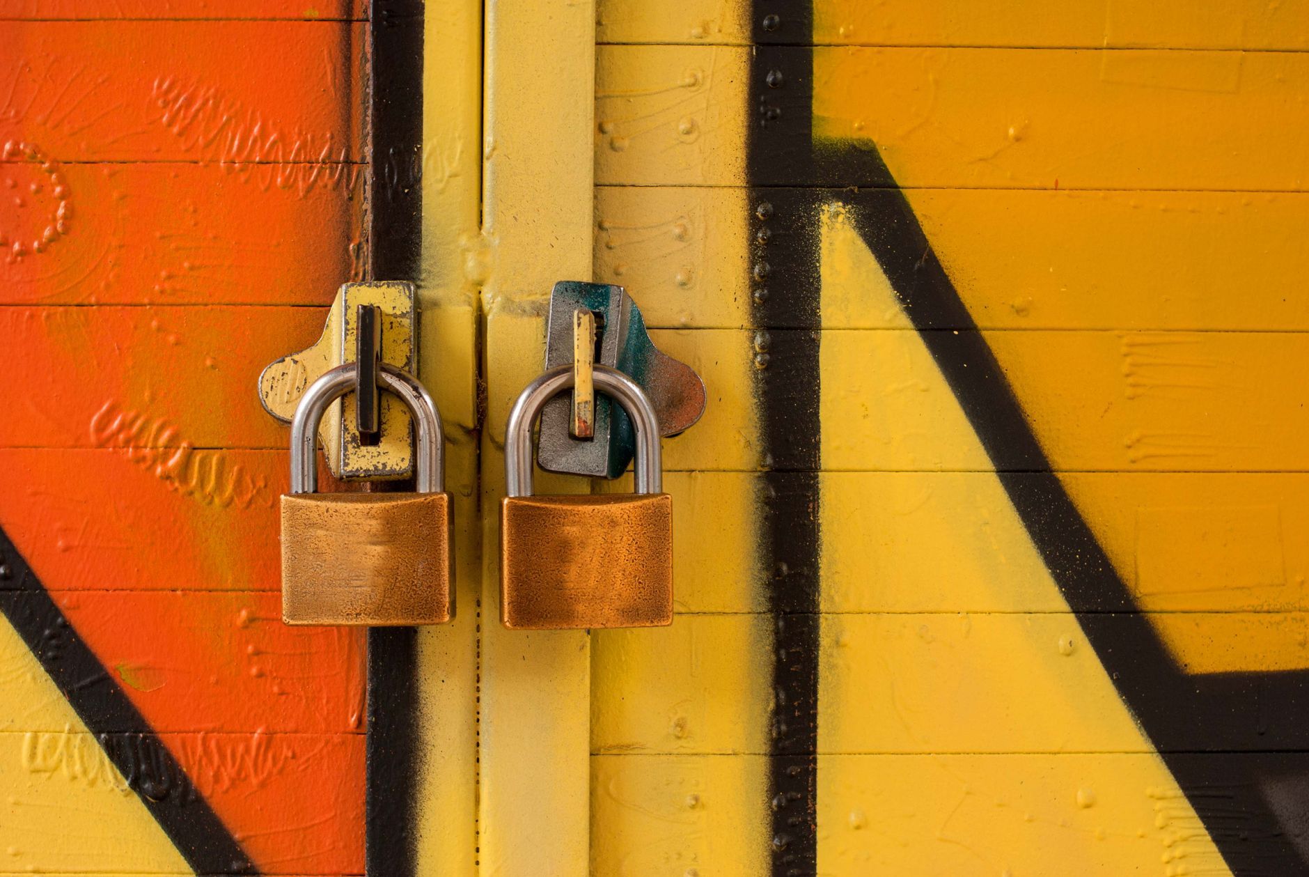 Two brass padlocks securing a painted door