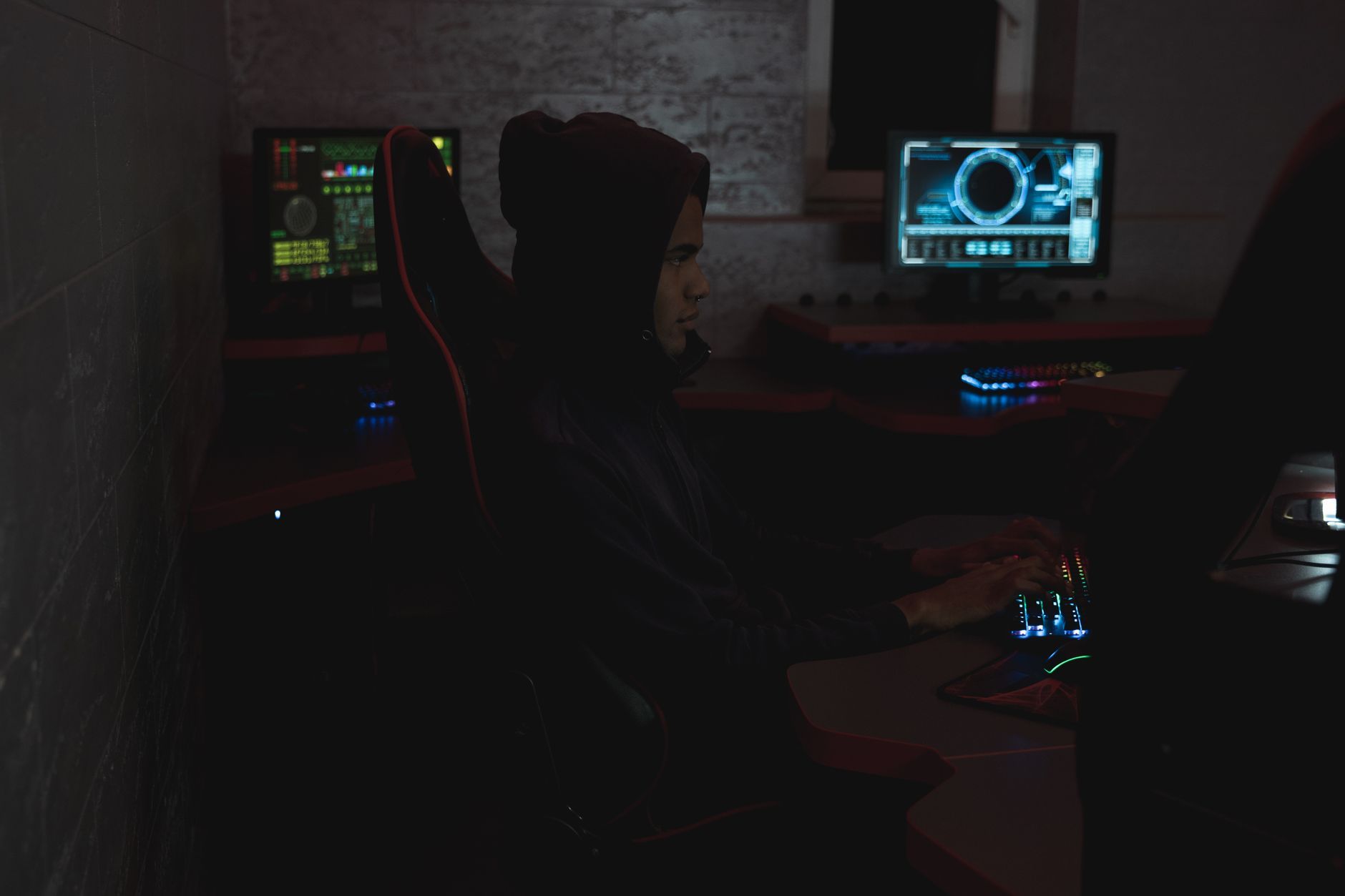 Security analyst reviewing alerts on multiple monitors in a dark operations room