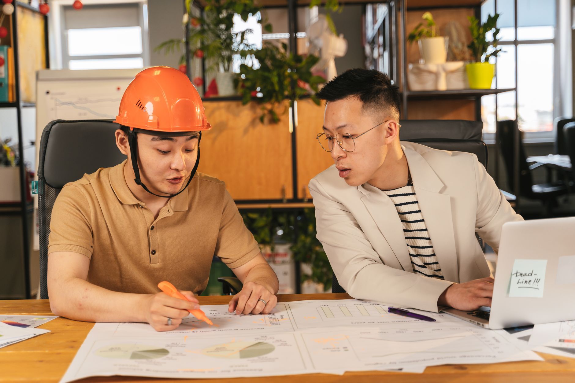 Two colleagues going through a set of documents together at a desk