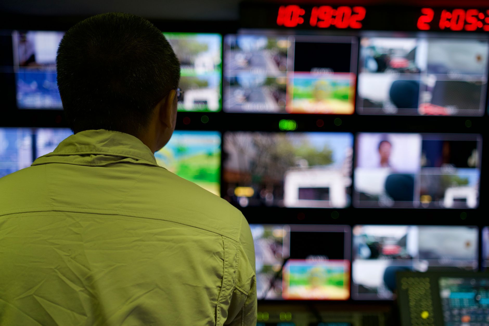 An operator in a control room watching a wall of monitors