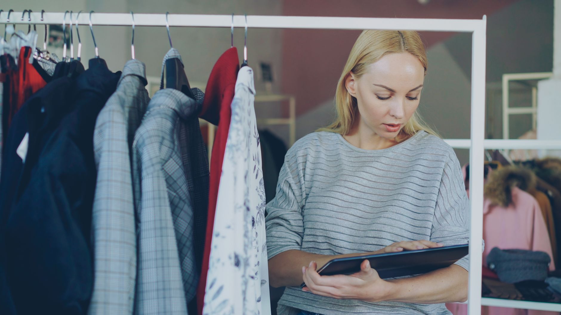 A shop assistant checking stock on a tablet in a clothing store, one of the in-store devices that now depends on an outlet's wireless network