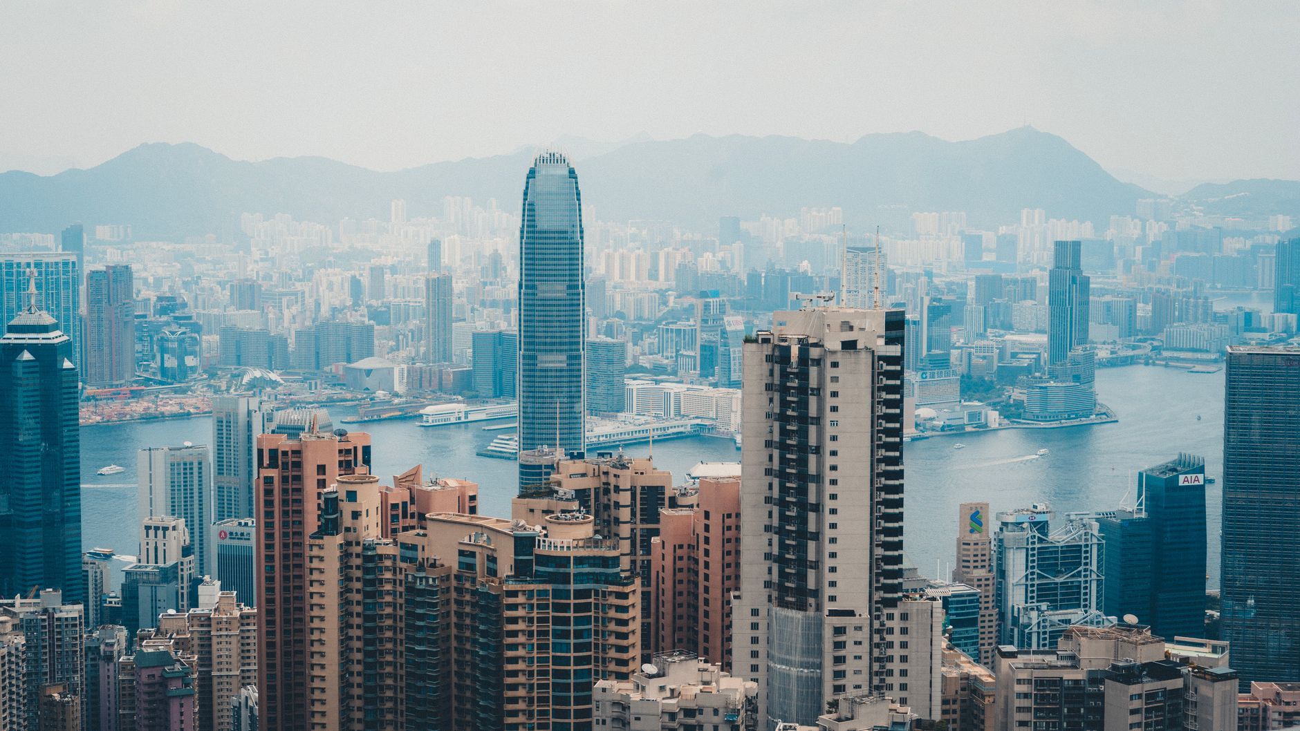 Hong Kong skyline and Victoria Harbour representing a regional headquarters coordinating branch offices across Asia and the UK