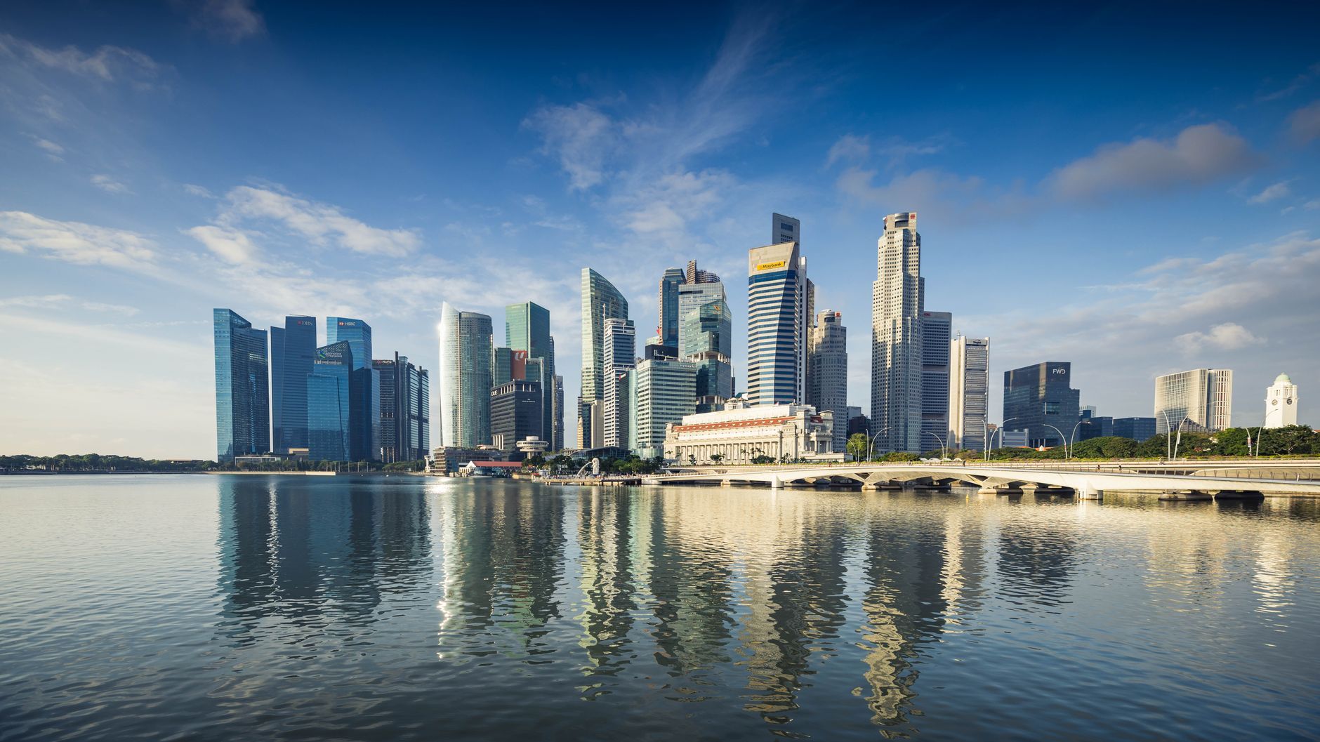 Modern reflective office towers of Singapore's business district against a clear blue sky, representing the managed IT service provider market serving companies across Hong Kong and Singapore