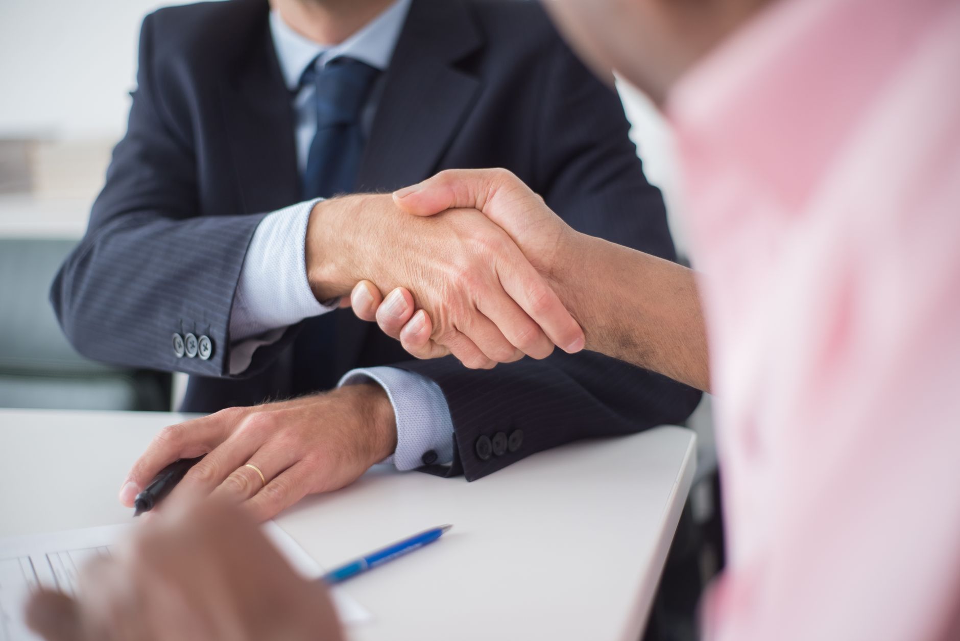 Two professionals meeting across a table in an office — the conversation in which a prime contractor decides whether a local delivery partner can actually hold the SLA it has already promised its own client