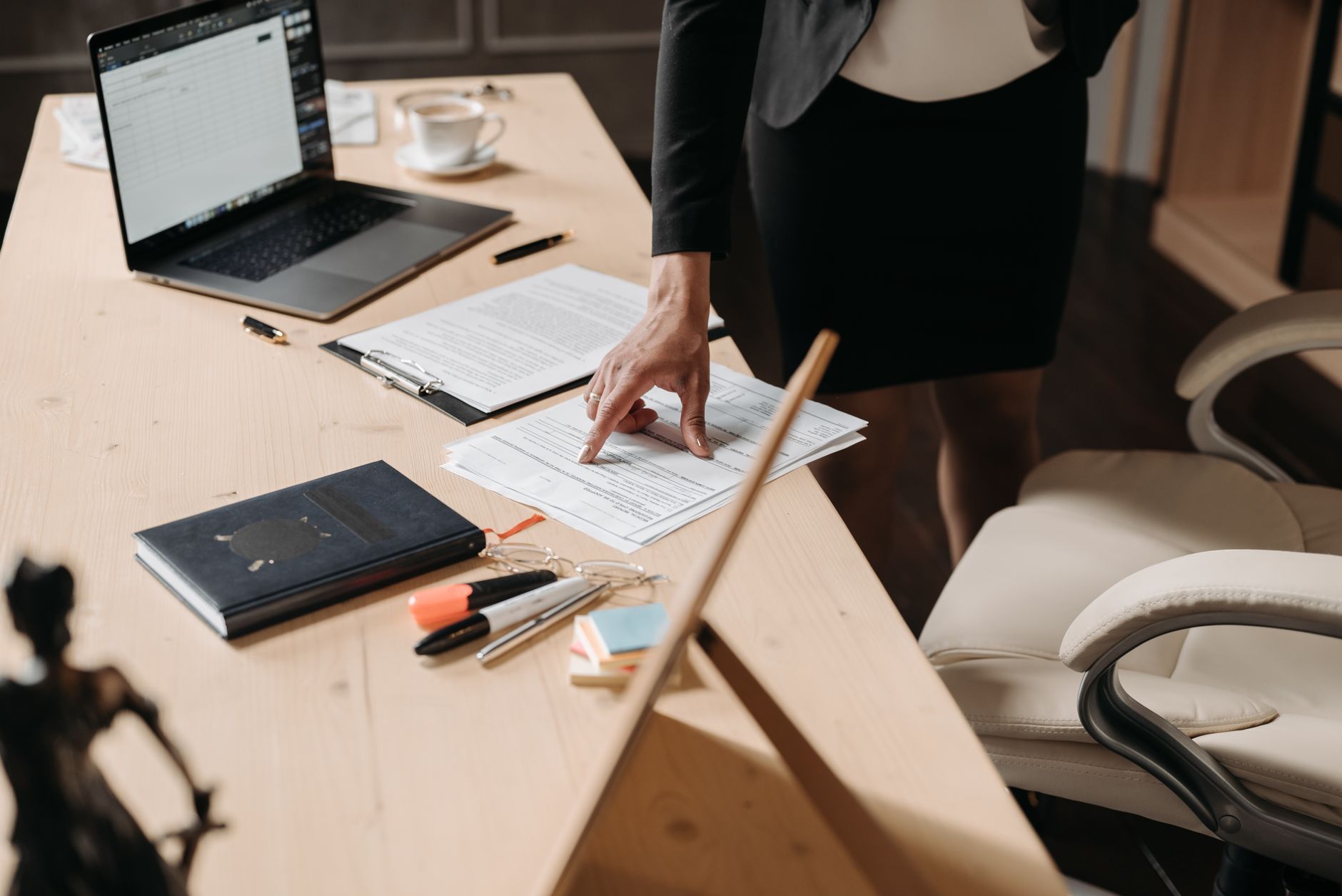 A businesswoman pointing at paperwork on a desk, representing reviewing an IT maintenance contract
