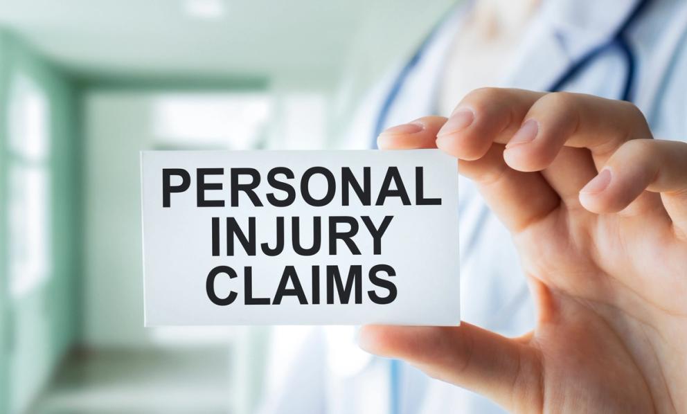 Hand holding card stating Personal Injury Claims