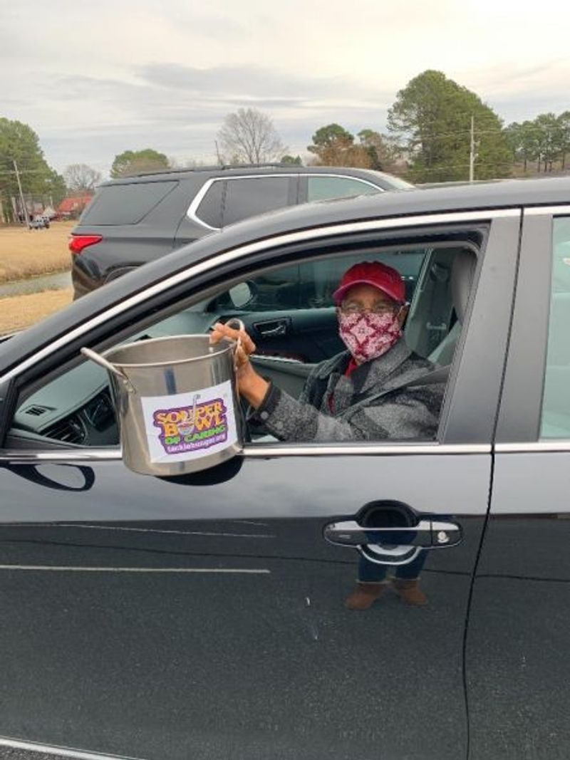 woman with soup pot in drive by fundraiser
