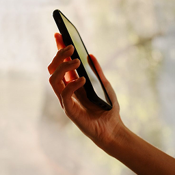 side view of half an arm holding a phone