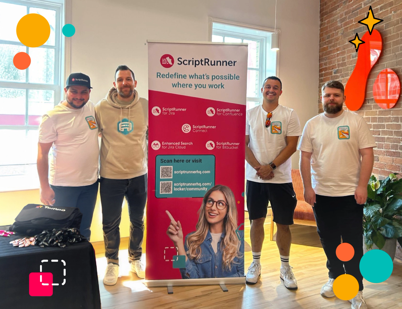 A photo of members of the ScriptRunner team with a ScriptRunner pull up banner at an event