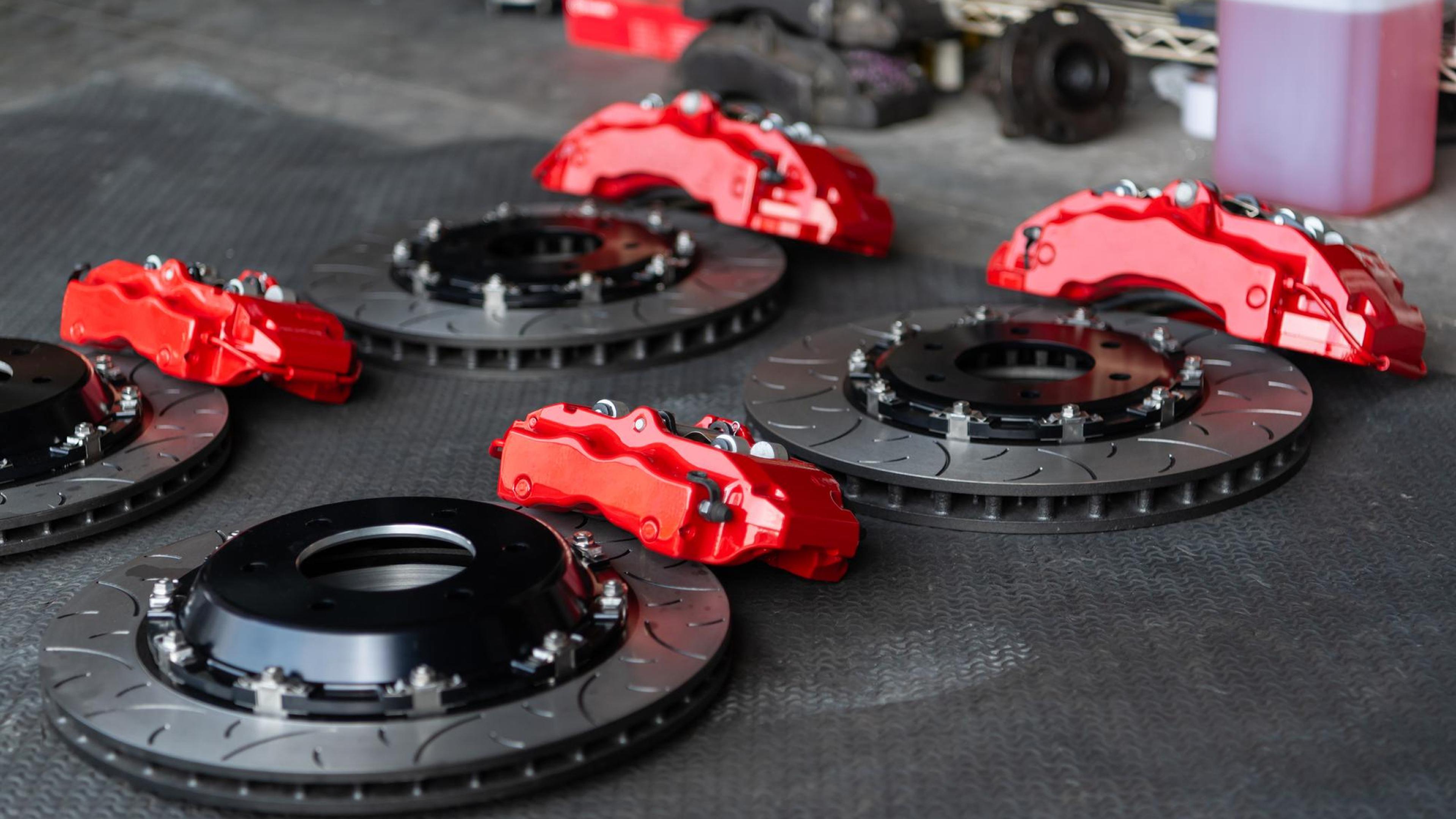 Hochleistungs-Bremsscheiben mit roten Bremssätteln auf Werkstattboden