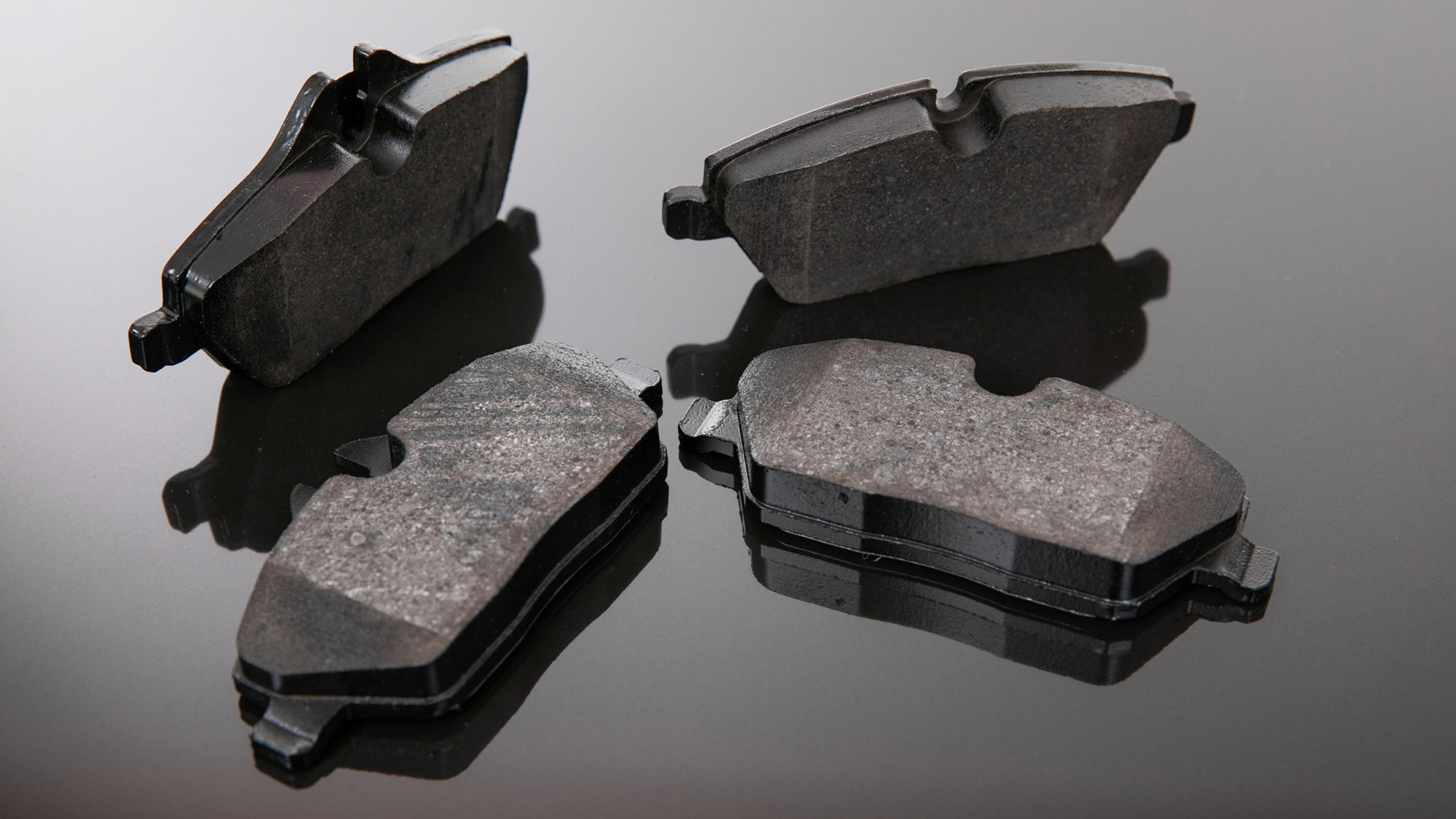 Four new brake pads for disc brakes on black background