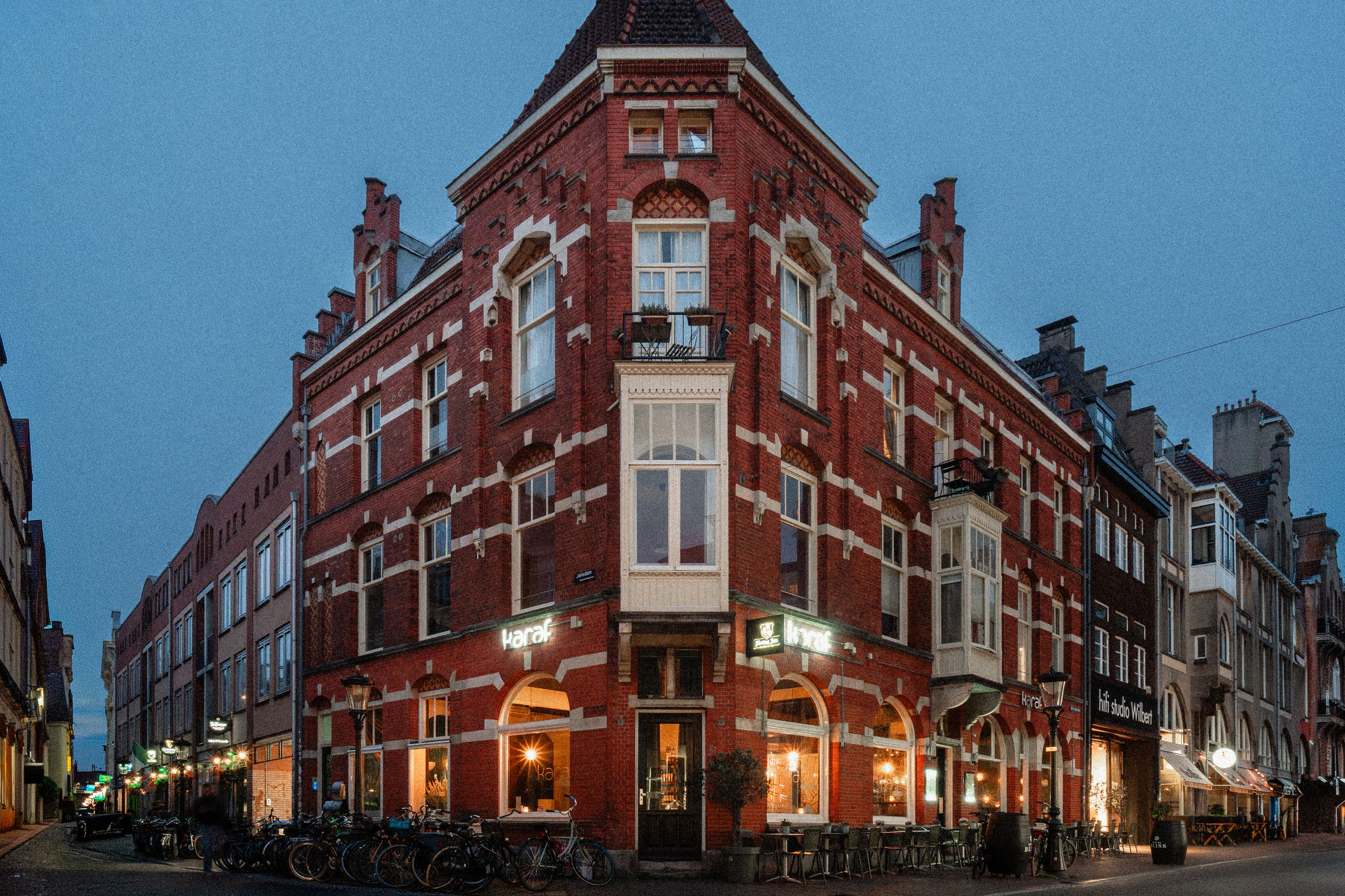 Buitenkant van restaurant Karaf aan de Lange Nieuwstraat in Utrecht, met rode bakstenen gevel en terras