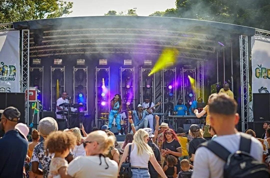 A singer performing on the carnival main stage in front of a crowd.
