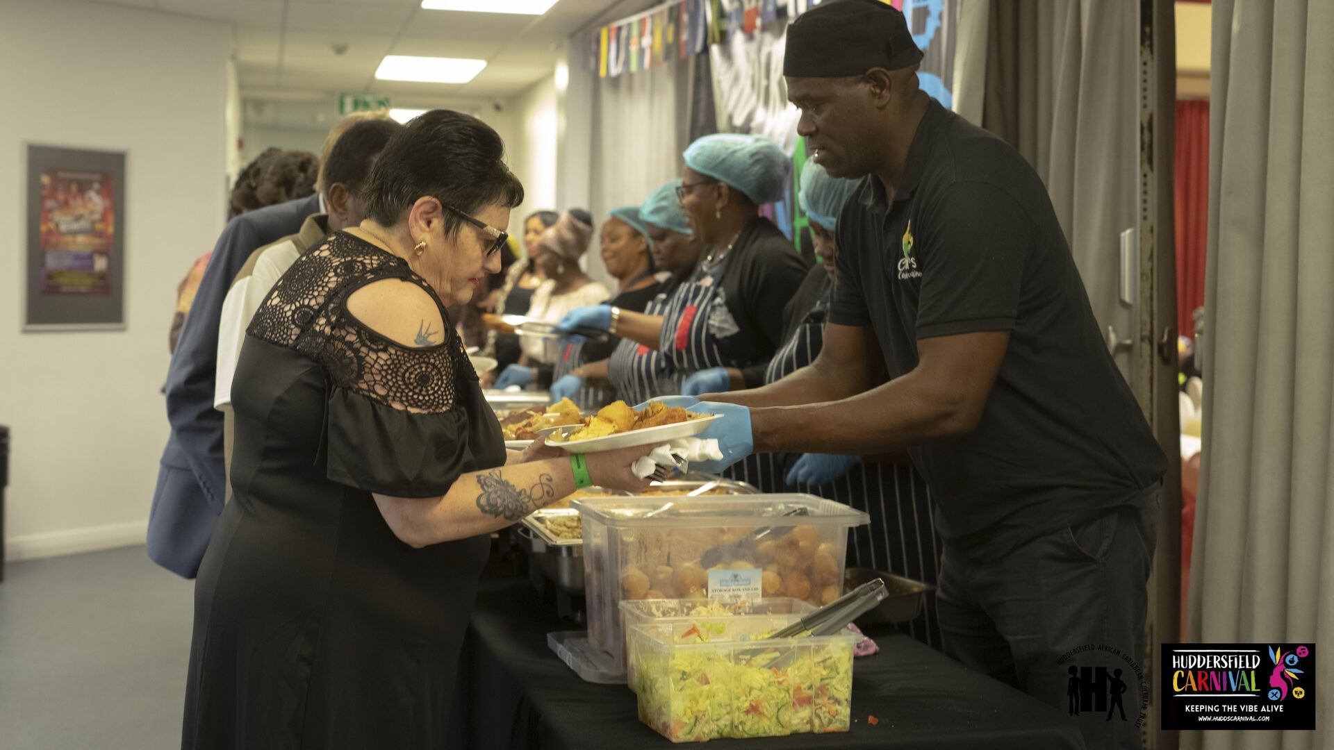 Trays of Caribbean food being served at a HACCT community dinner.
