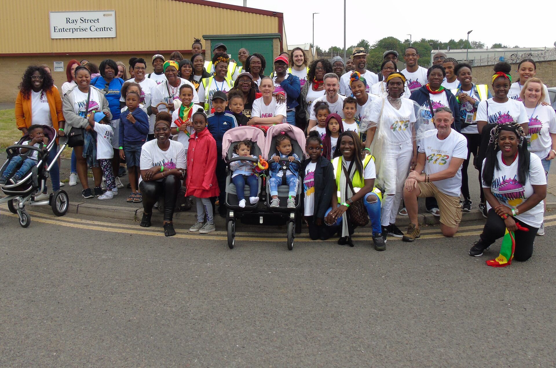Walk 4 Carnival — a community group photo of dozens of supporters in matching white t-shirts.