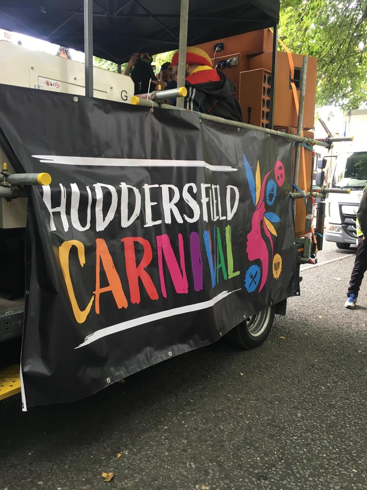 A Huddersfield Carnival sound system float draped in banners.