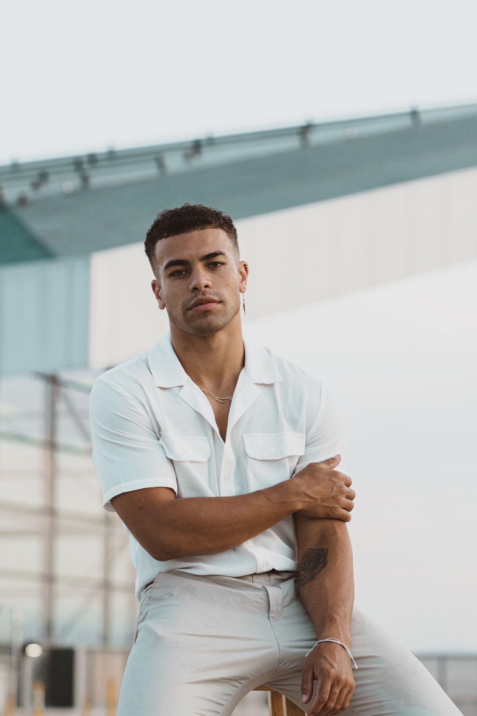 Young man in a white shirt leaning on a wall