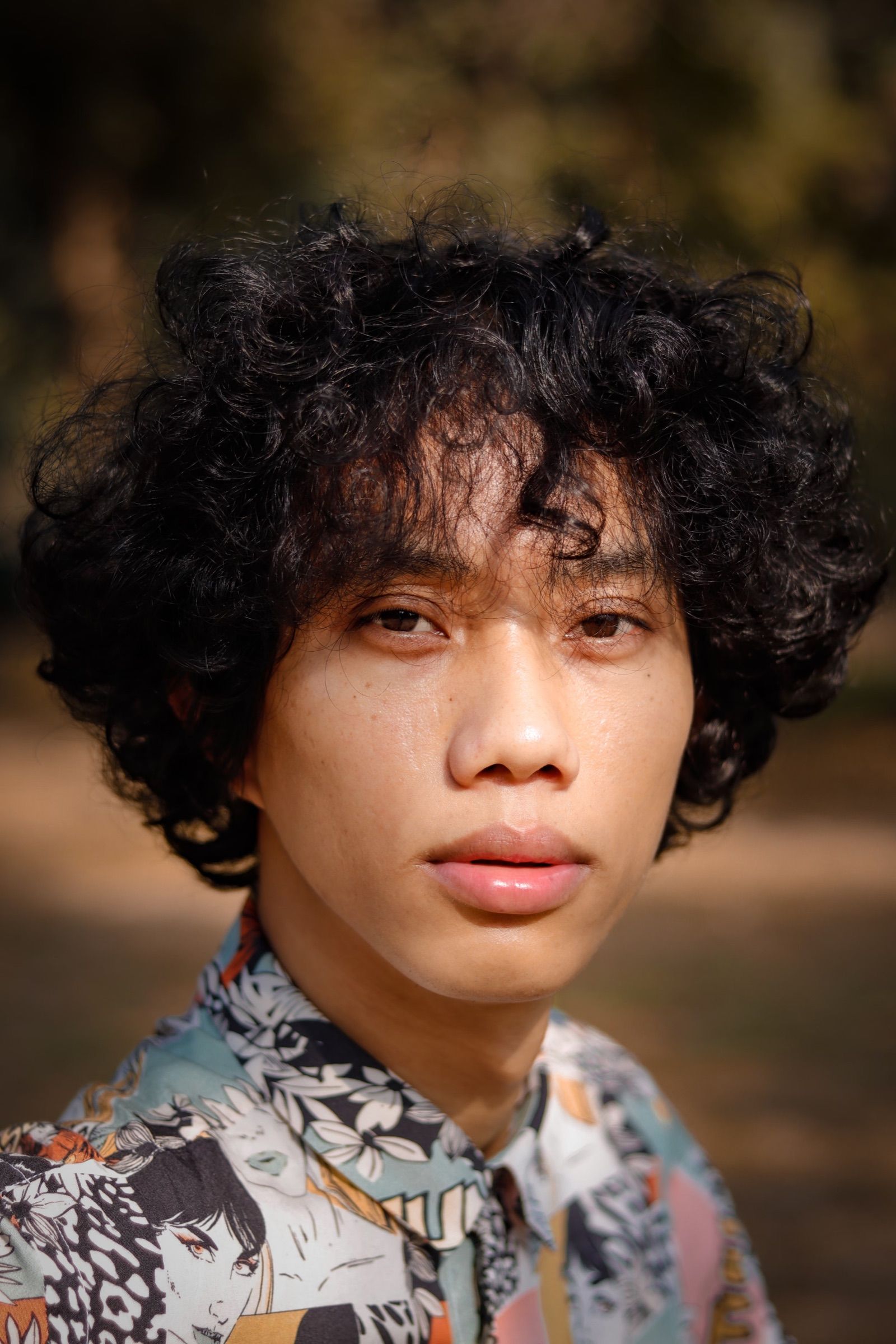 Portrait of a young person with curly black hair