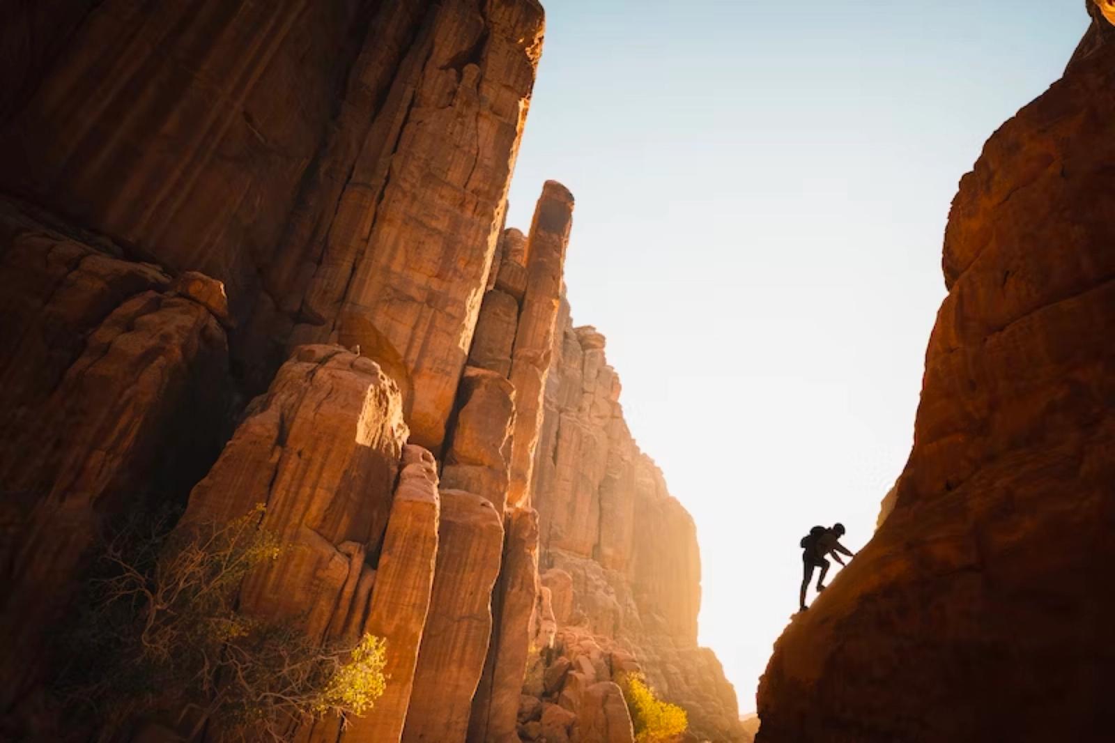 Climber on a sandstone cliff at sunset