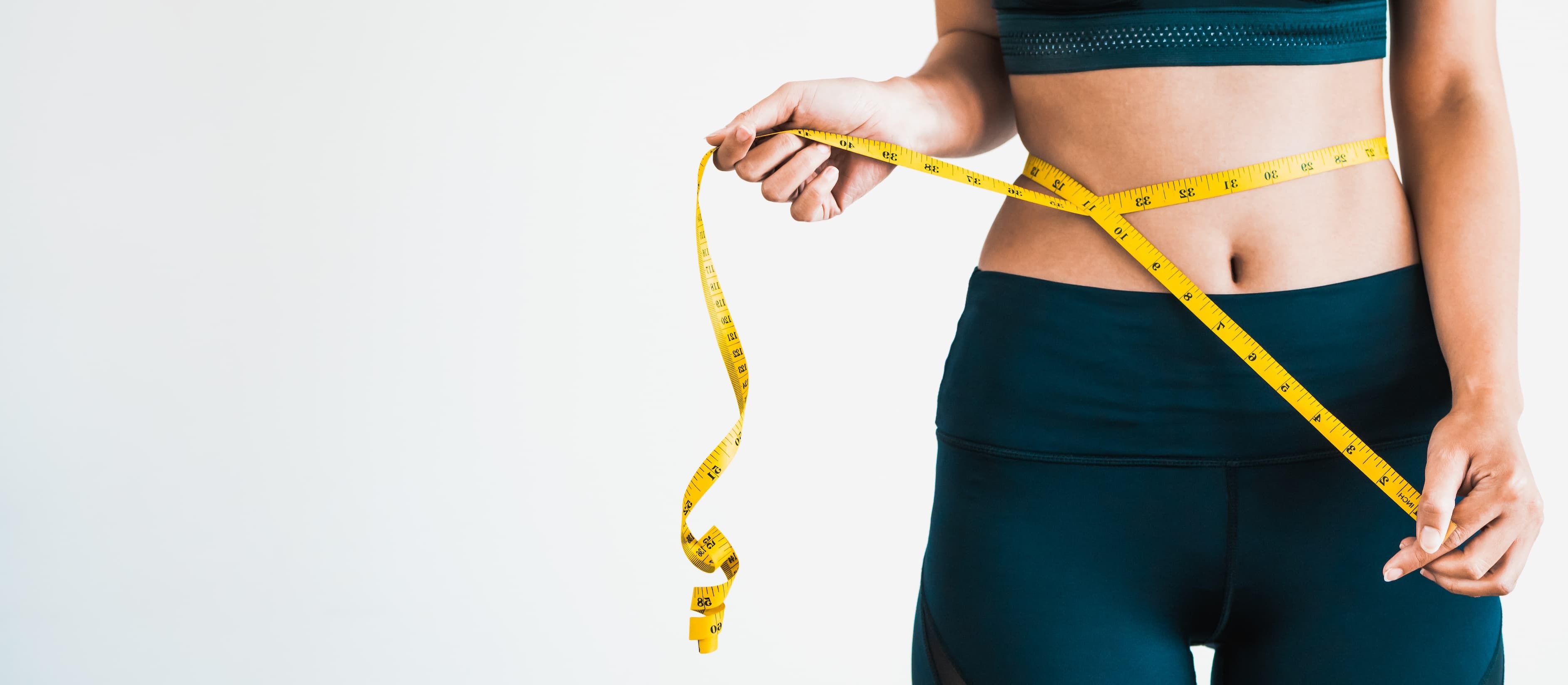 lady using measuring tape on her waistline