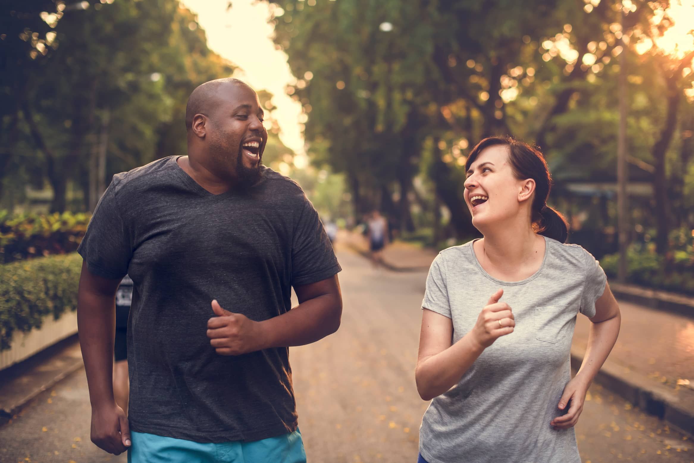man and woman laughing while running