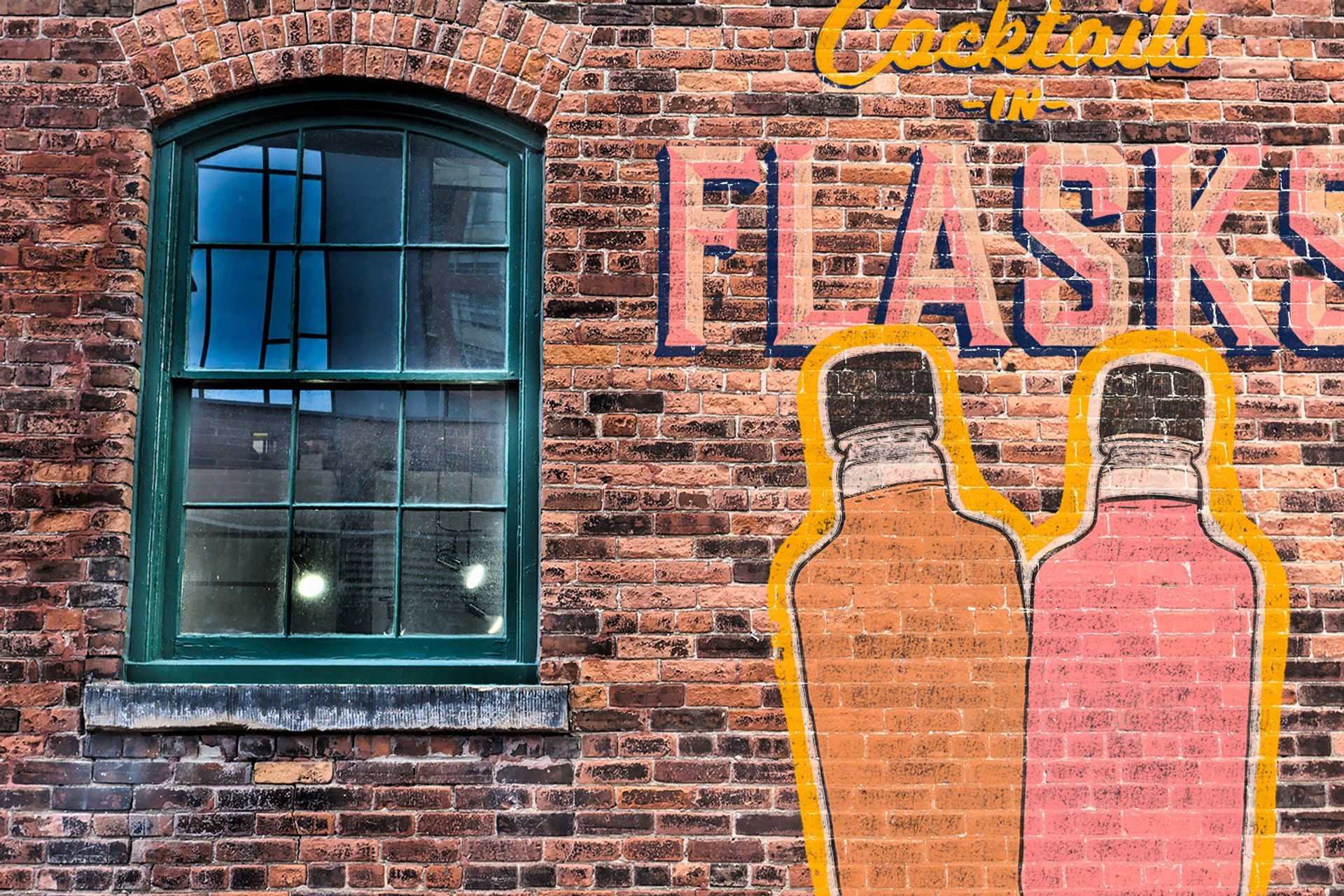 Ghost sign reading Cocktails in Flasks on a brick wall