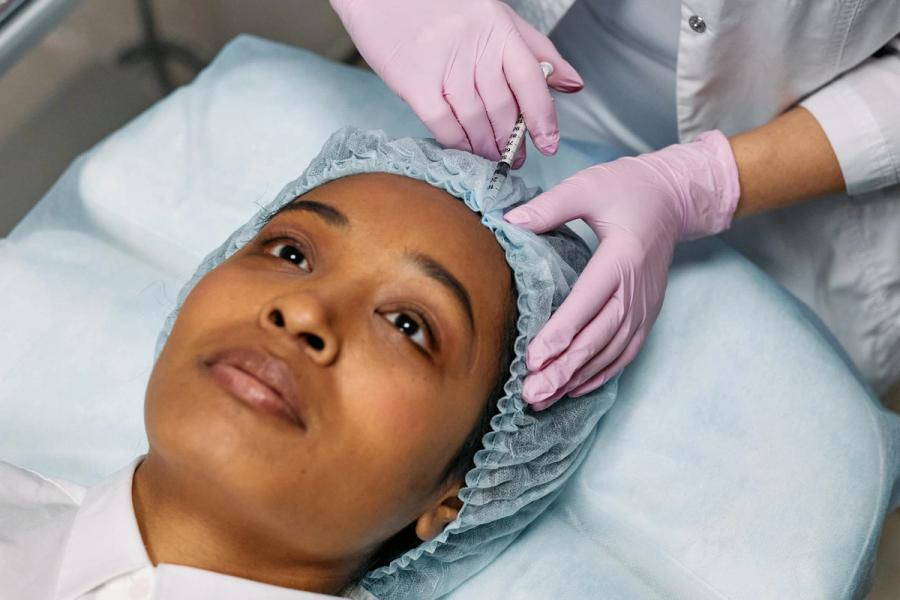 Clinician performing an injectable aesthetic treatment in a modern clinic (stock photo)