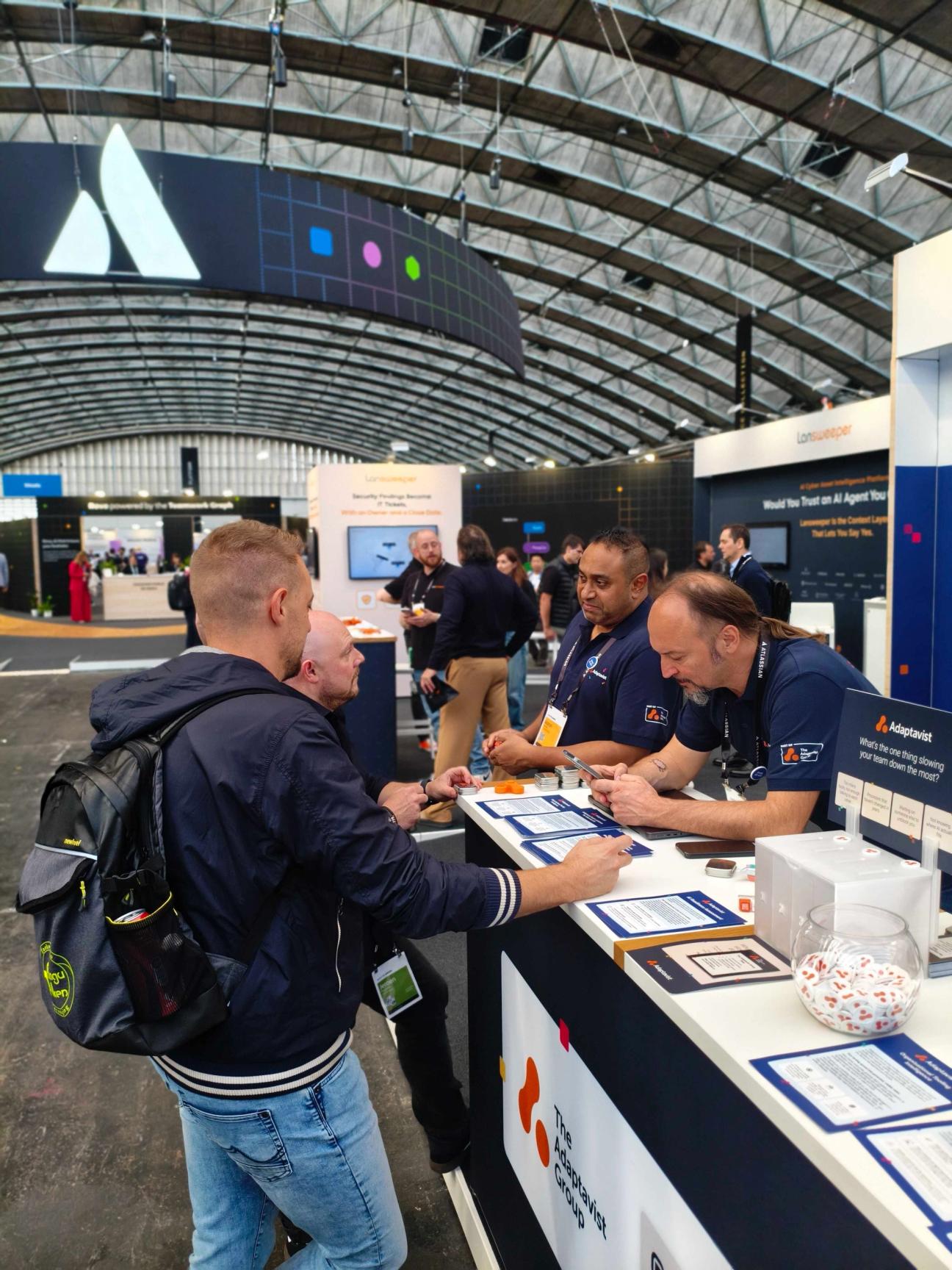 Adaptavist team sharing ideas with customer on the booth