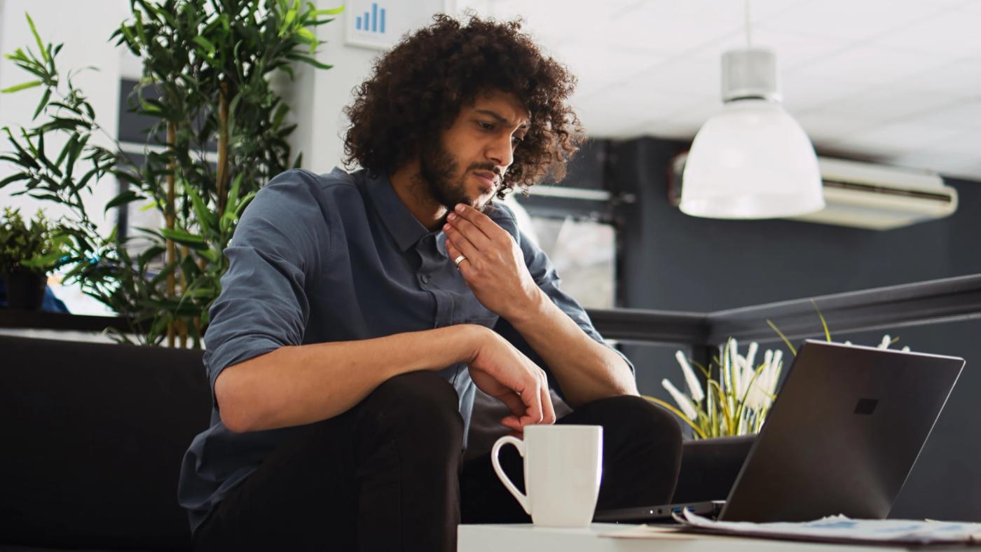 Person sat at laptop looking worried