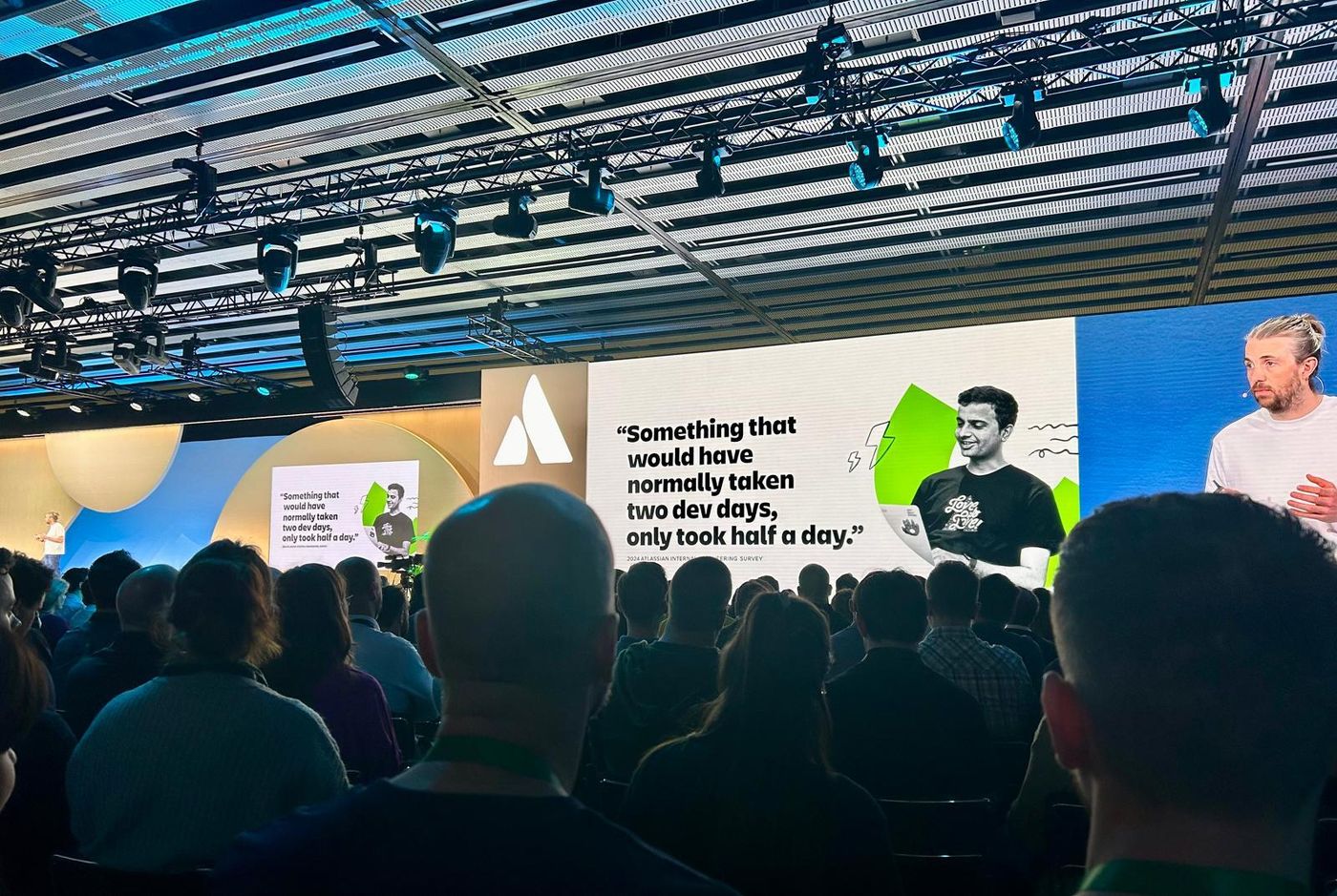 Immagine di un presentatore e alcuni messaggi presenti sul palco dell’evento Atlassian Team 24