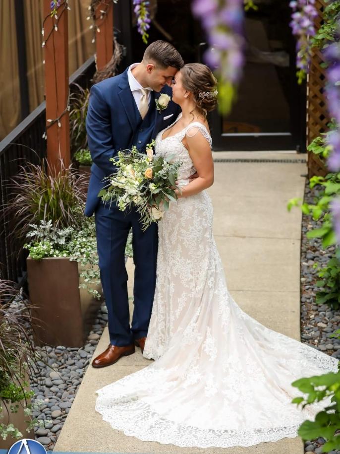 Bride wearing a fitted lace wedding gown purchased at Aleana’s Bridal.