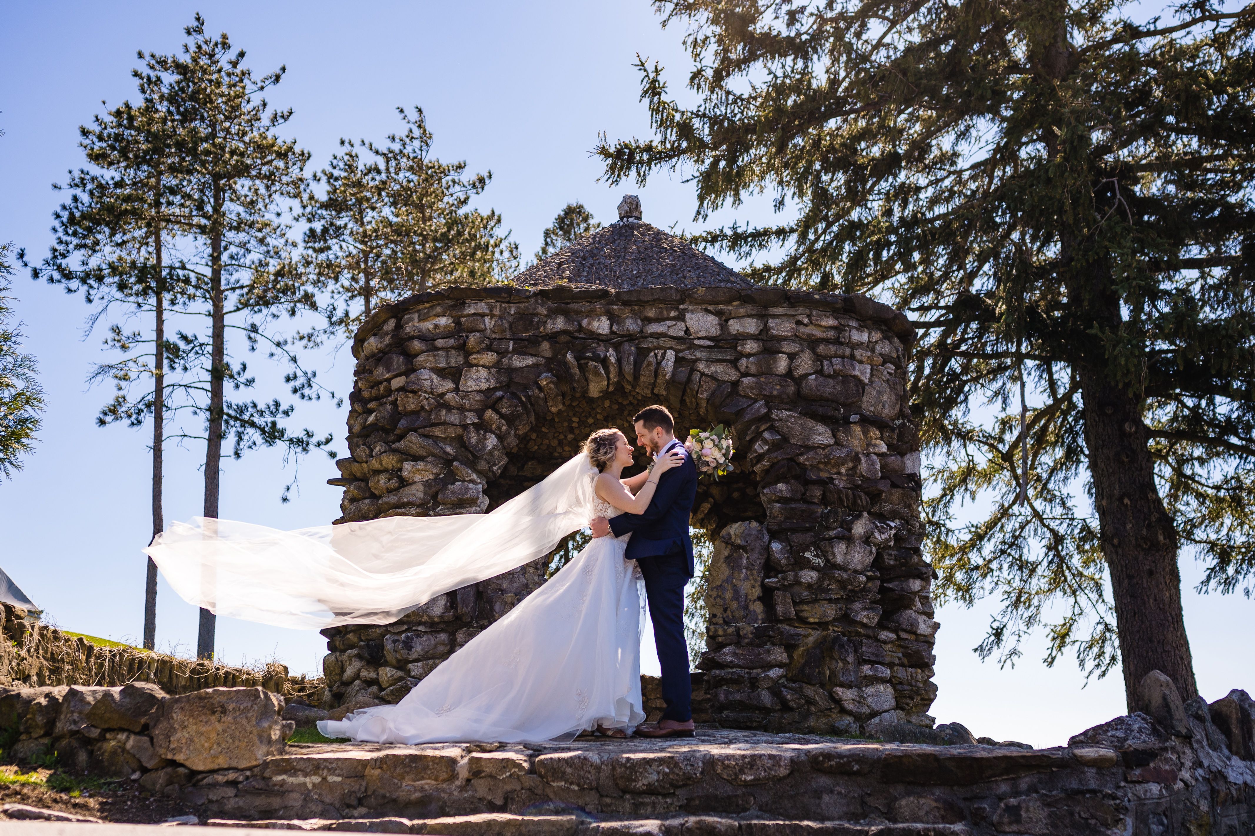 Bride posing outdoors in a luxury designer wedding dress from Aleana’s Bridal