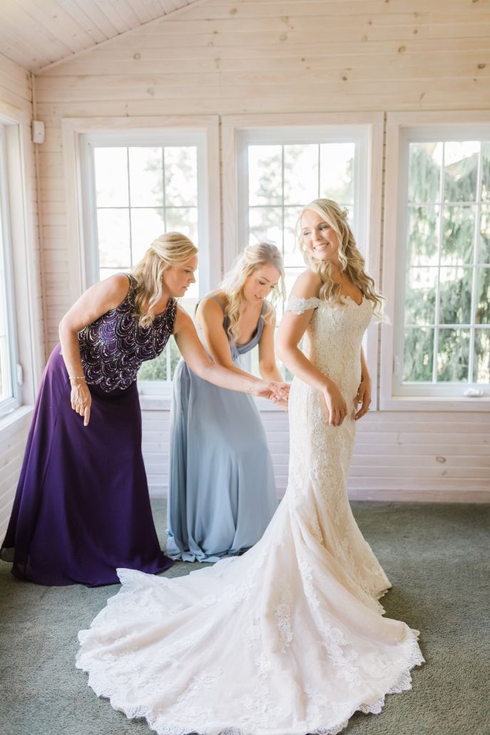 Happy bride in a classic off-the-shoulder wedding dress from Aleana’s Bridal
