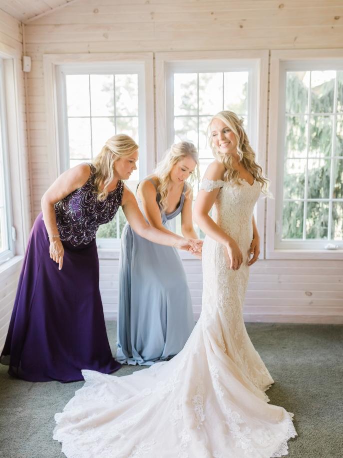 Happy bride in a classic off-the-shoulder wedding dress from Aleana’s Bridal