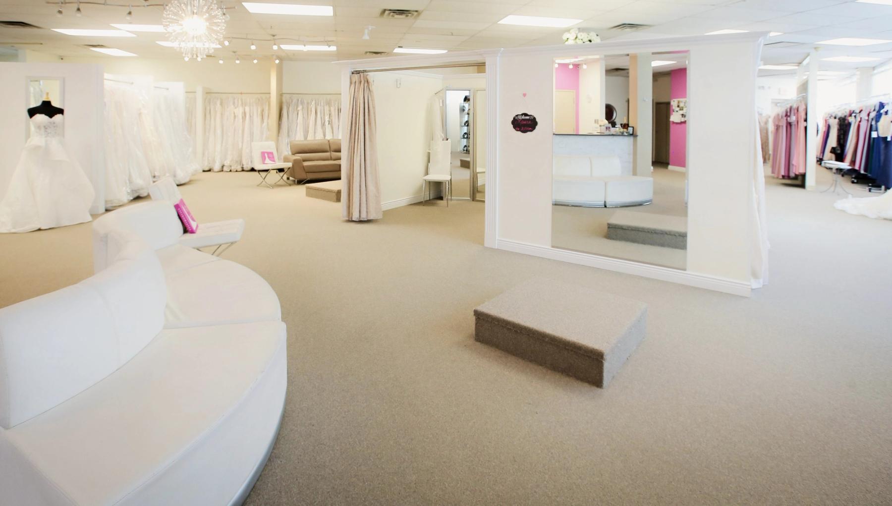 The salon at Aleana's Bridal, with white seating, mirrors and the fitting platform