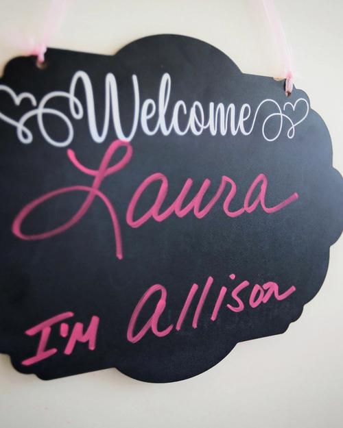 A chalkboard welcome sign greeting a bride by name at Aleana's Bridal