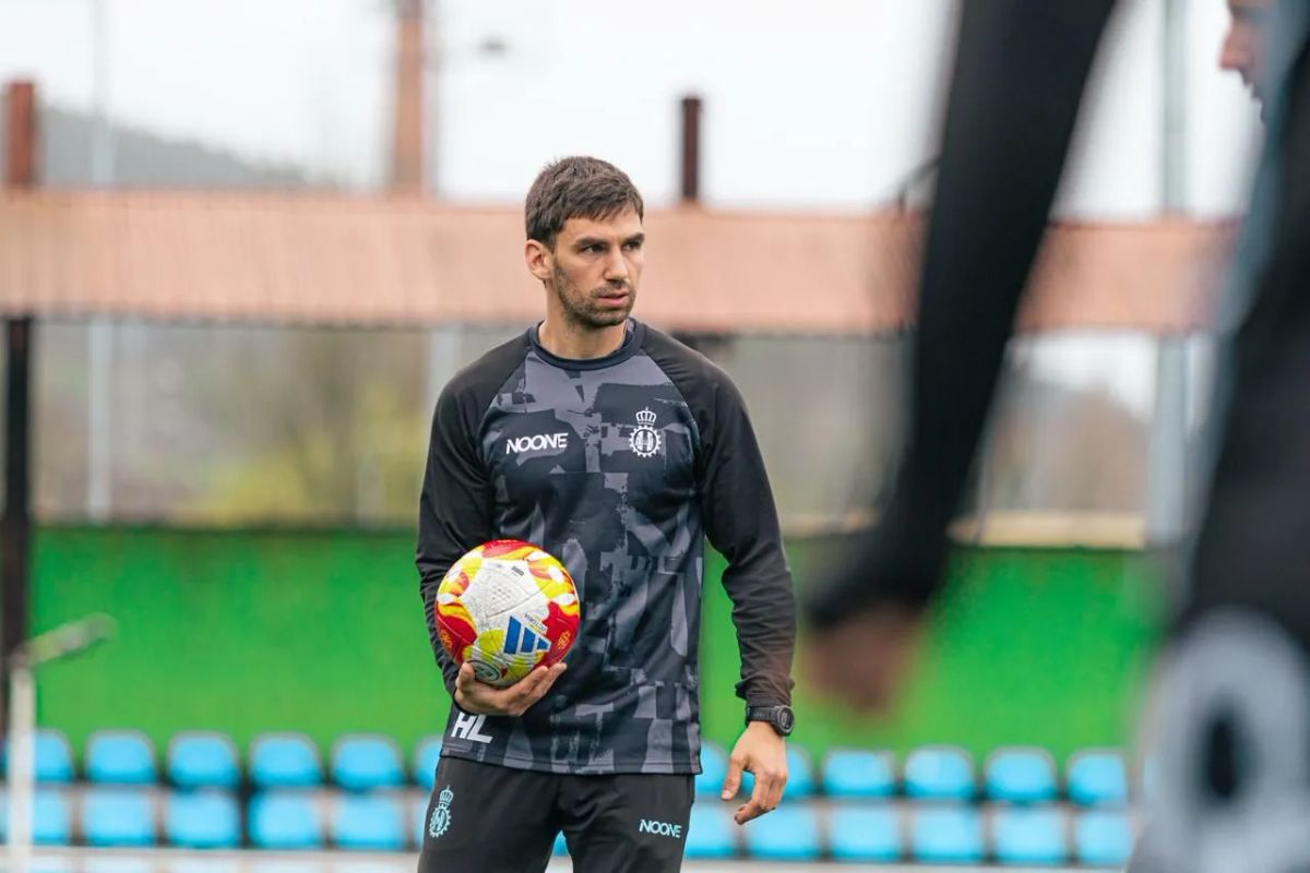 Hugo Laviana con un balón en la mano en el banquillo