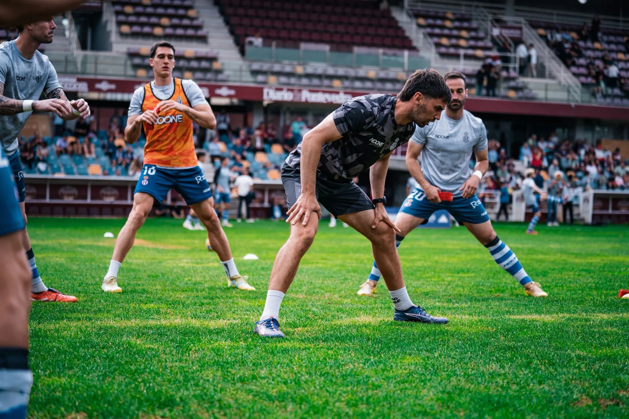 Hugo Laviana dirigiendo el calentamiento de un equipo de fútbol en el estadio