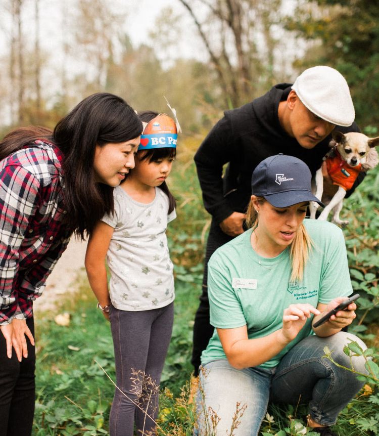 A Discover Parks Ambassador shows park visitors something