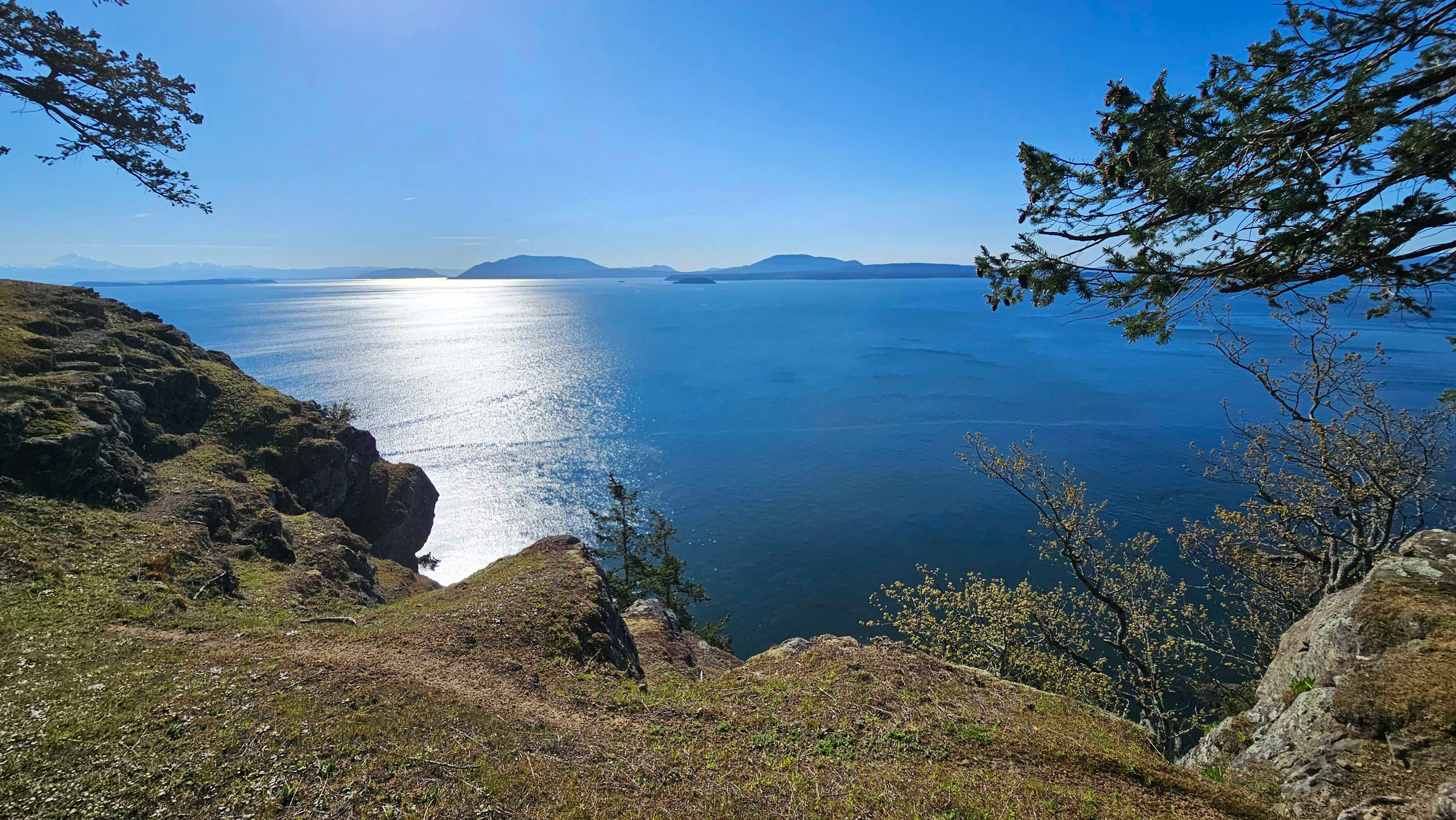 A shimmering ocean beneath a cliff face