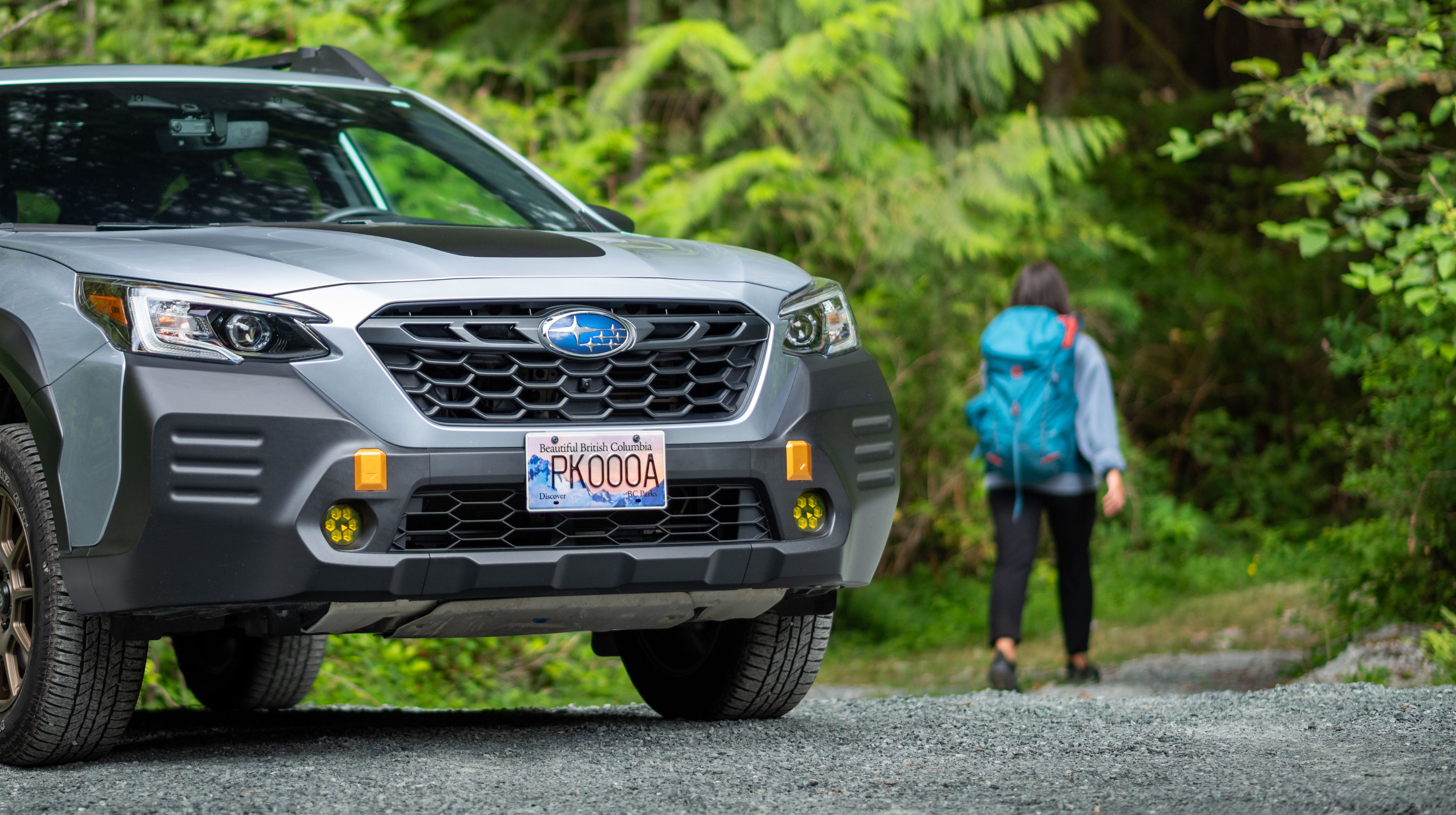 Car wearing BC Parks license plate with trail user in background
