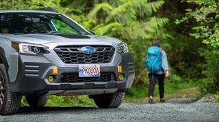 Car wearing BC Parks license plate with trail user in background