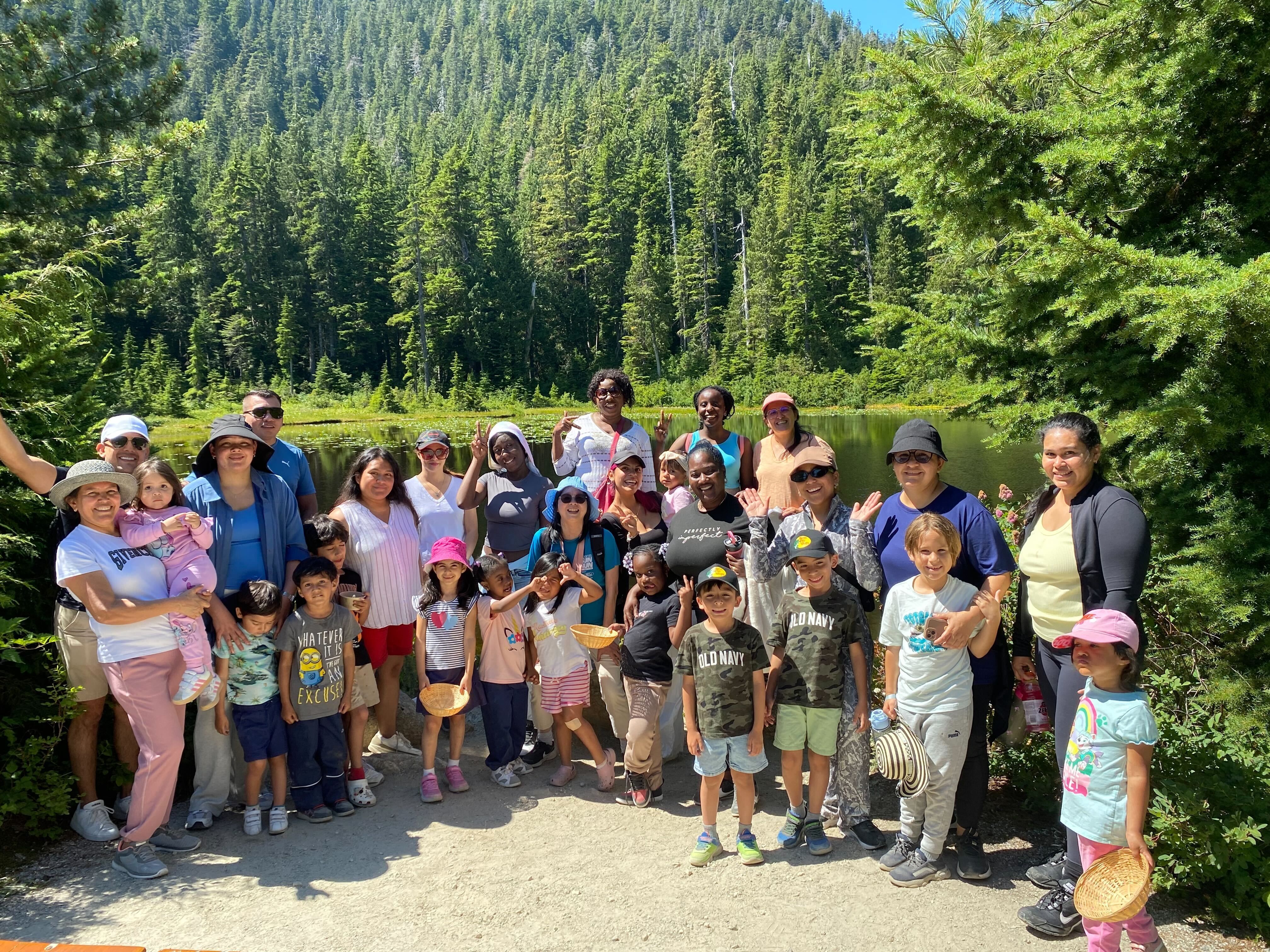 PIRS members smile for a group photo in front of lake and forest.
