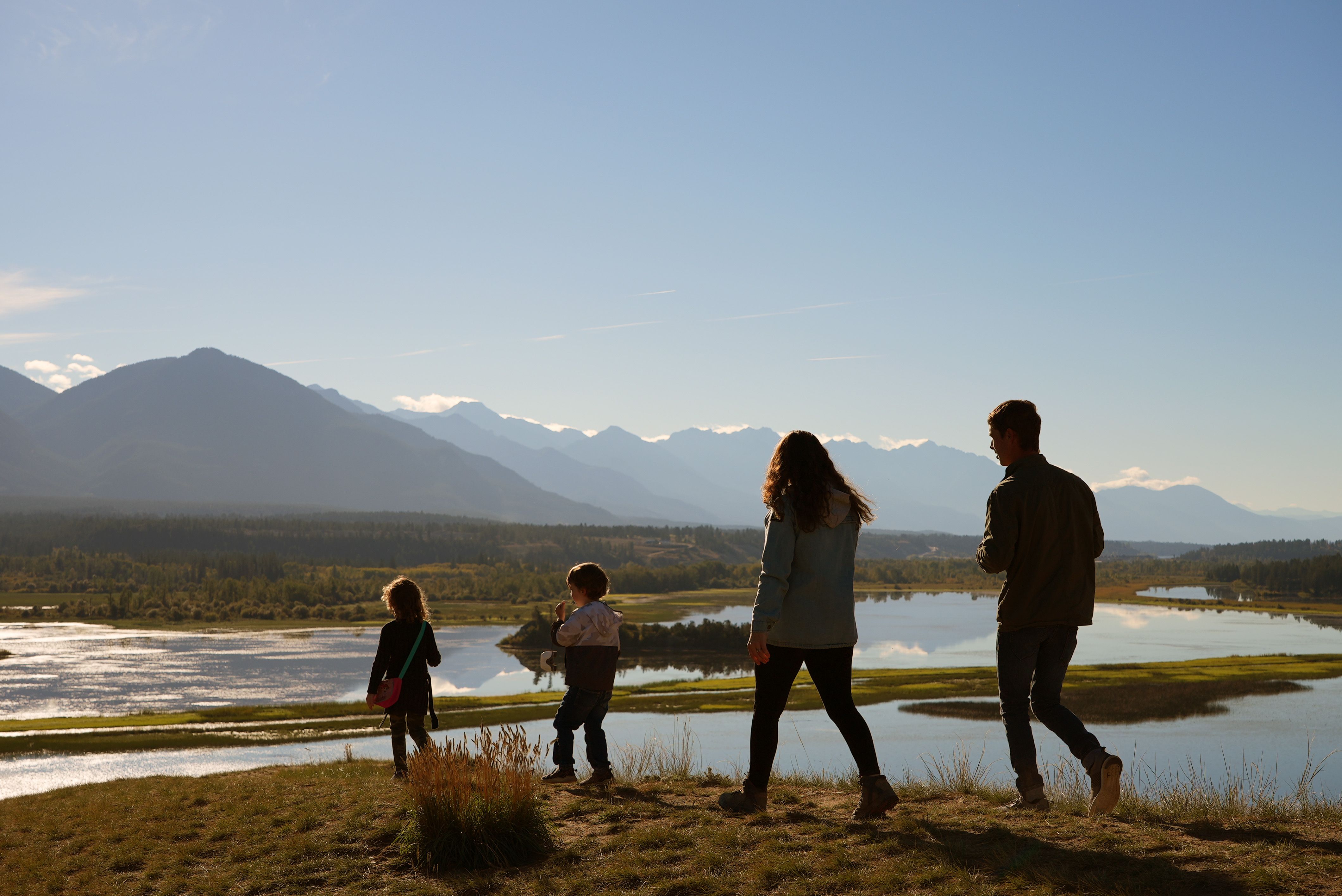 A family walk through a sandy, mountainous waterbank